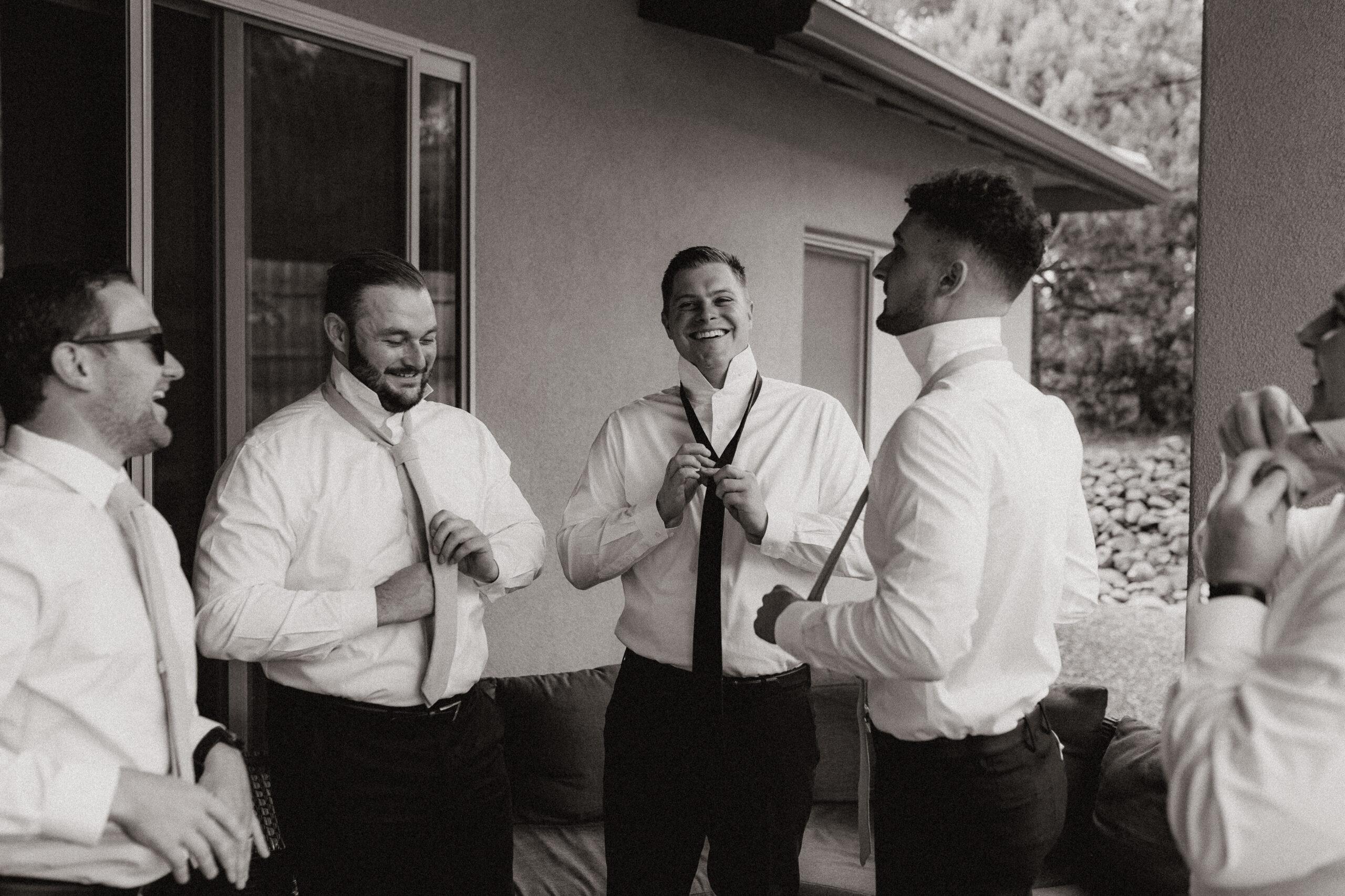 black and white of groomsmen getting ready