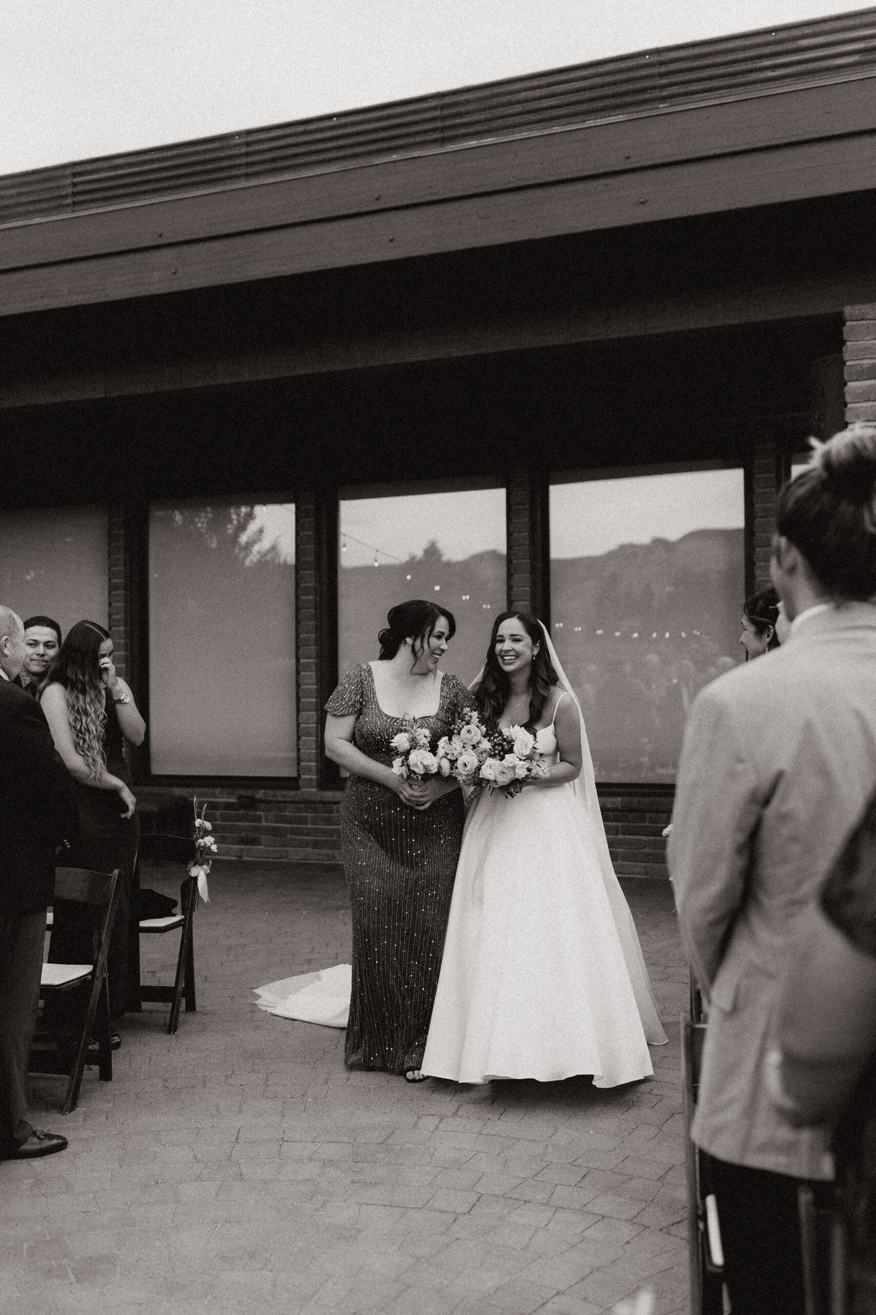 mom and bride walking down aisle 