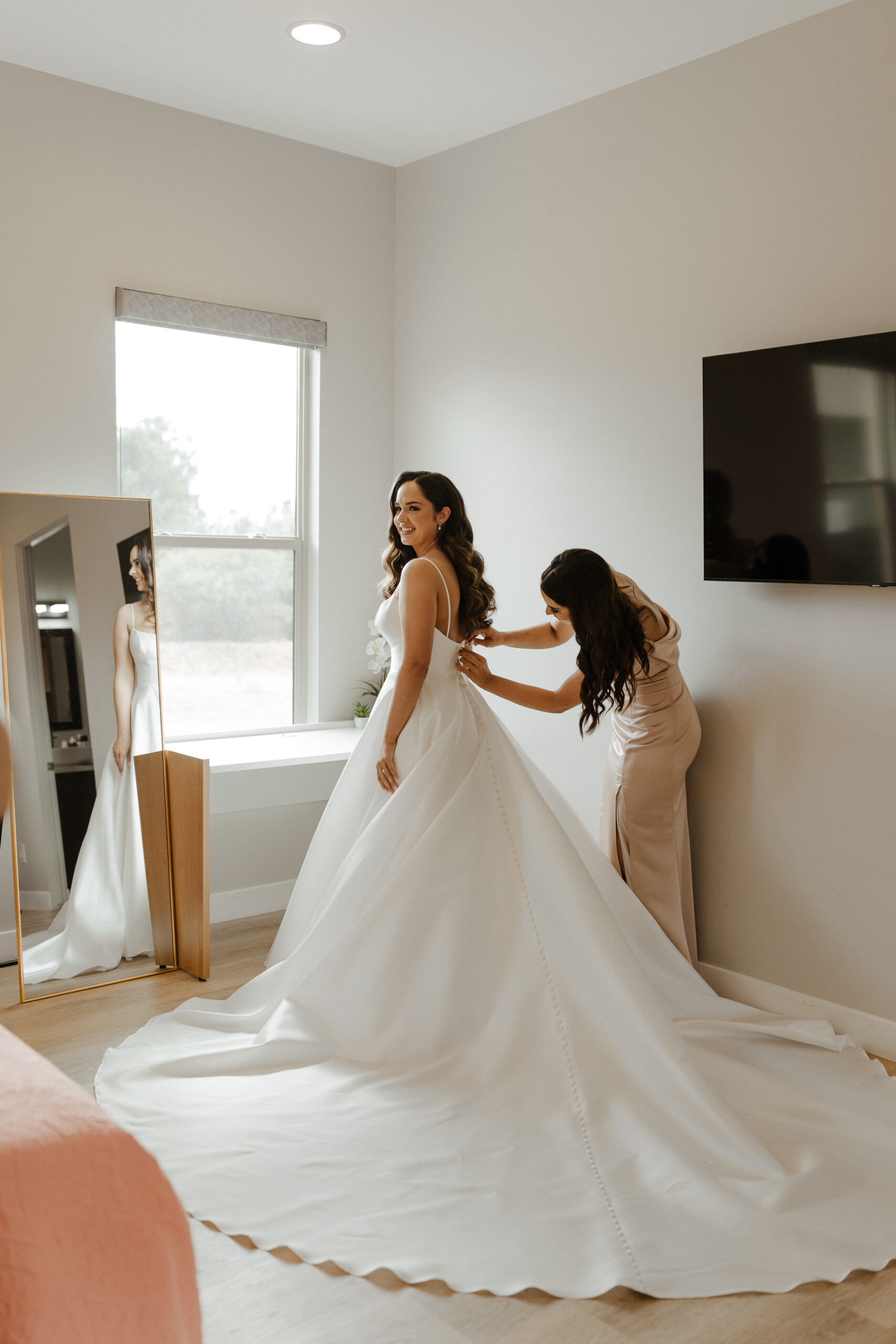 bride putting dress on with help