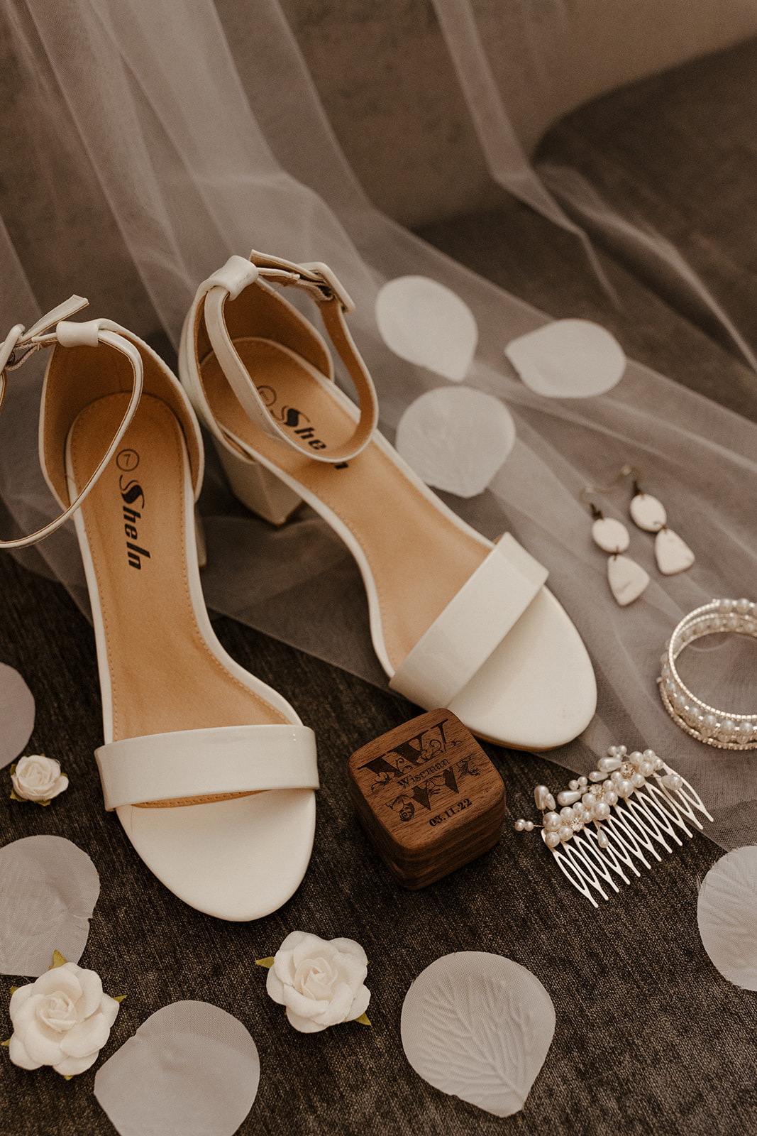 bride detail shot. shoes, veil, flower petals, jewelry 
