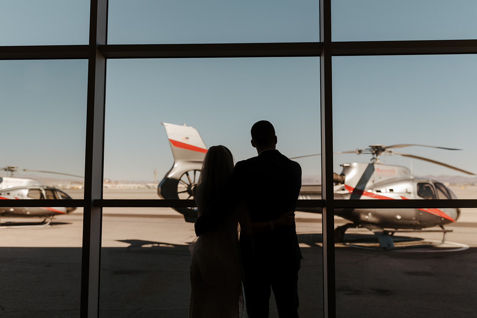 bride and groom looking out the window at terminal