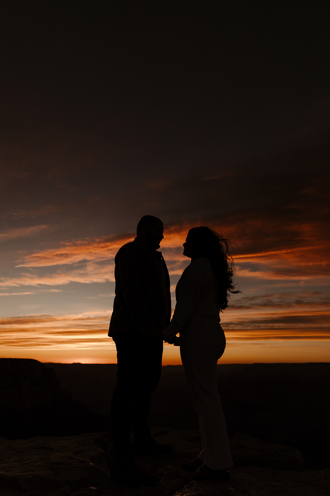 beautiful color sunset with engaged couple shadow
