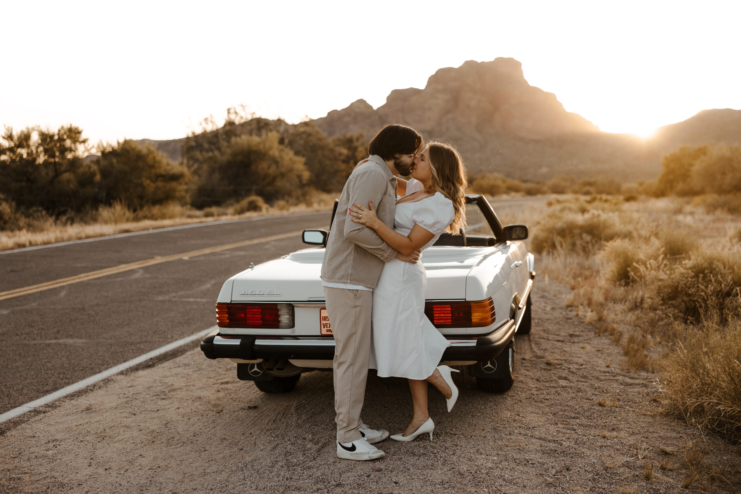 couple at the back of the car kissing at vintage car engagement photos 