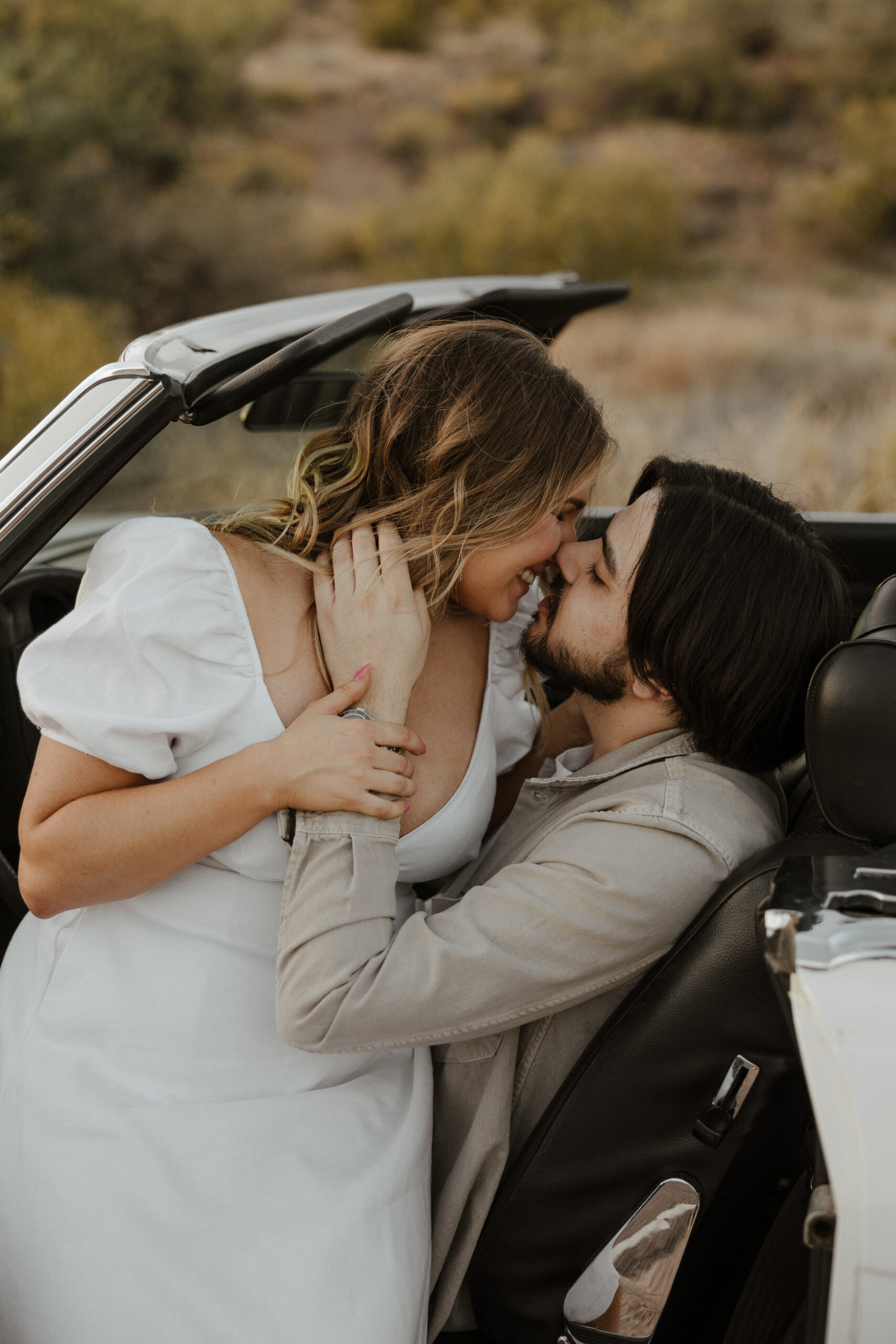 couple sitting in the car kissing for vintage car engagement photos 