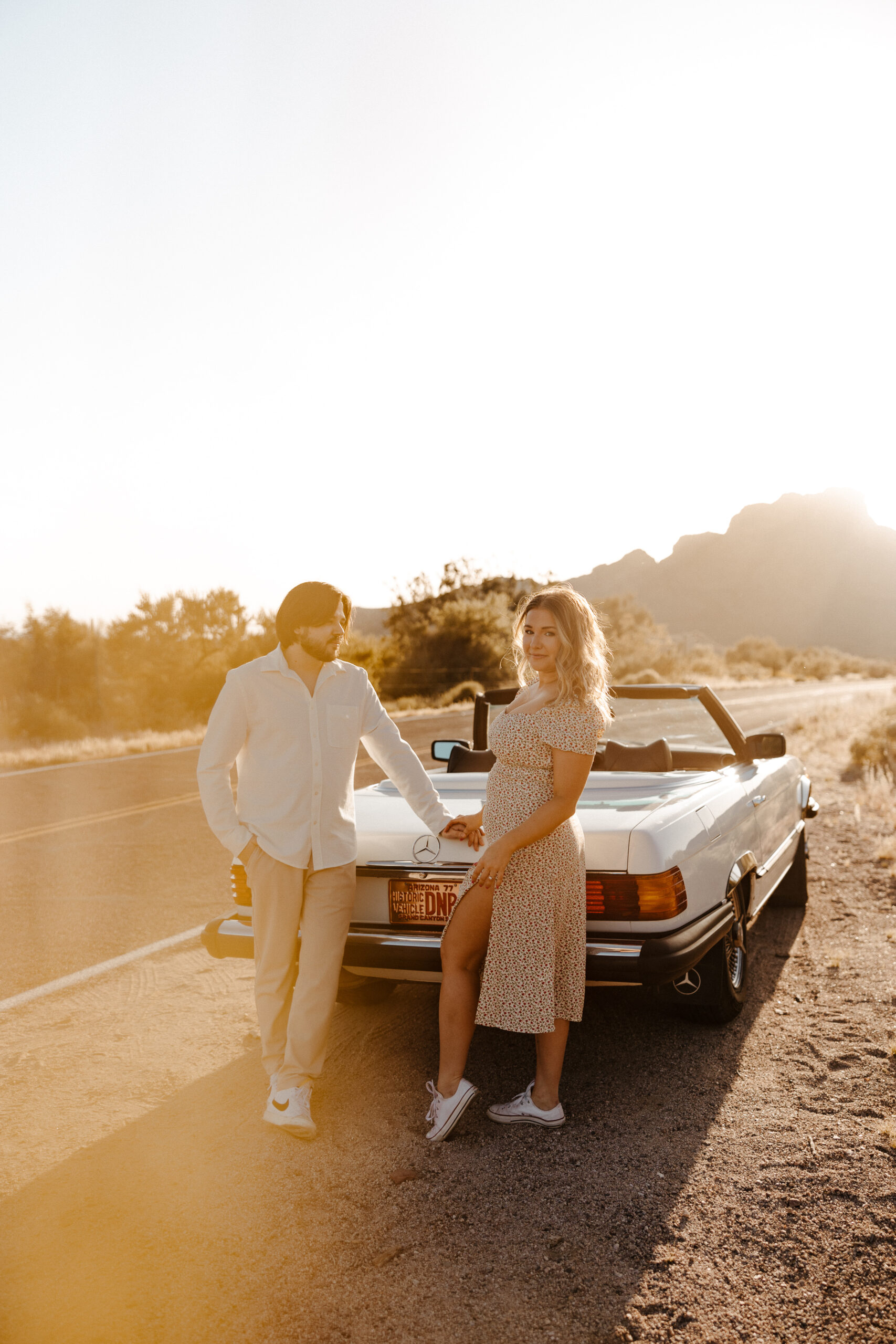 couple at the back of car holding hands for vintage car engagement photos