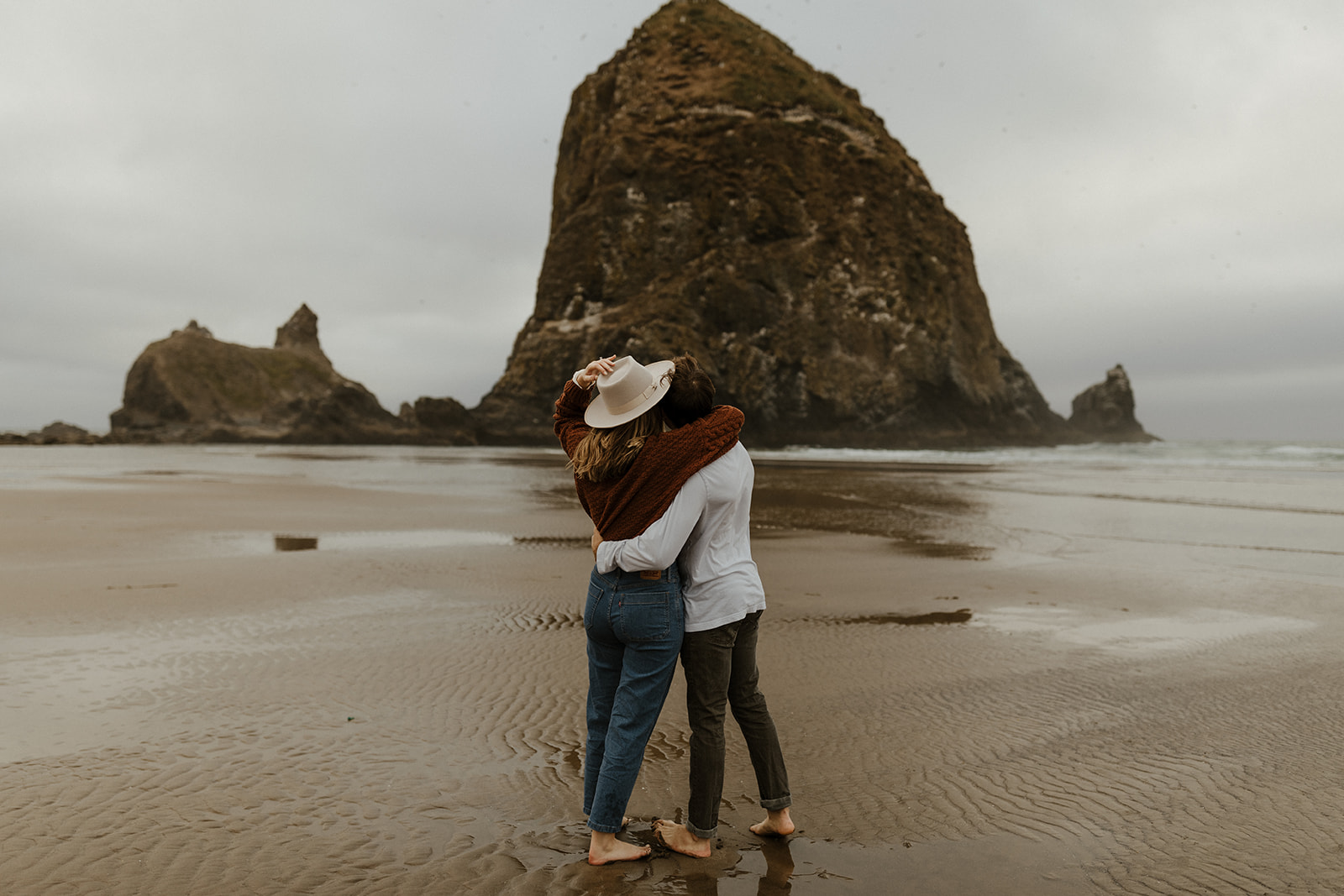 couple looking out at haystack rock 