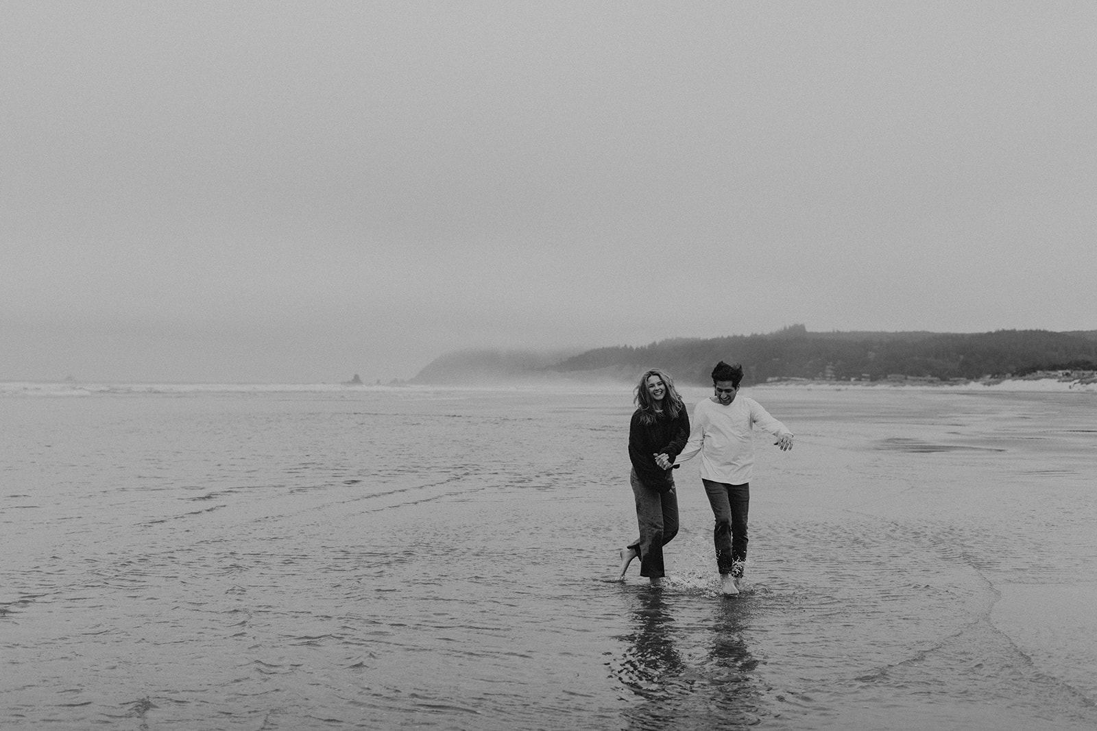 black and white of couple walking in the ocean