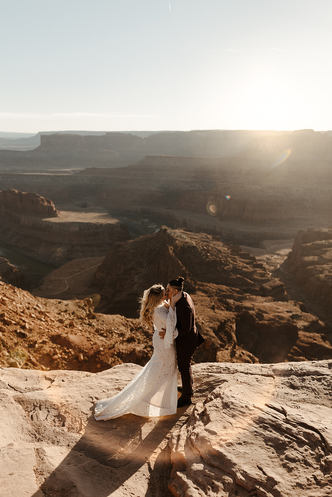 bridal couple kissing at moab elopement with scenery in the background