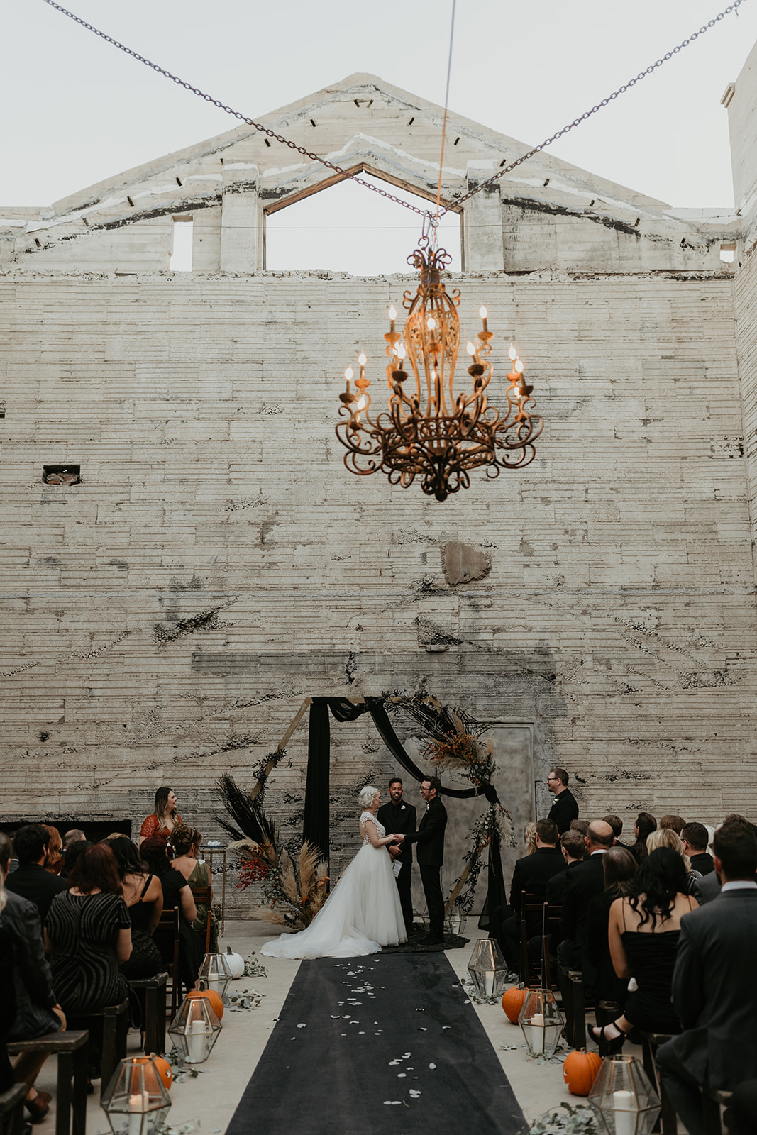 bride and groom at moody altar during the ceremony at fall halloween wedding 