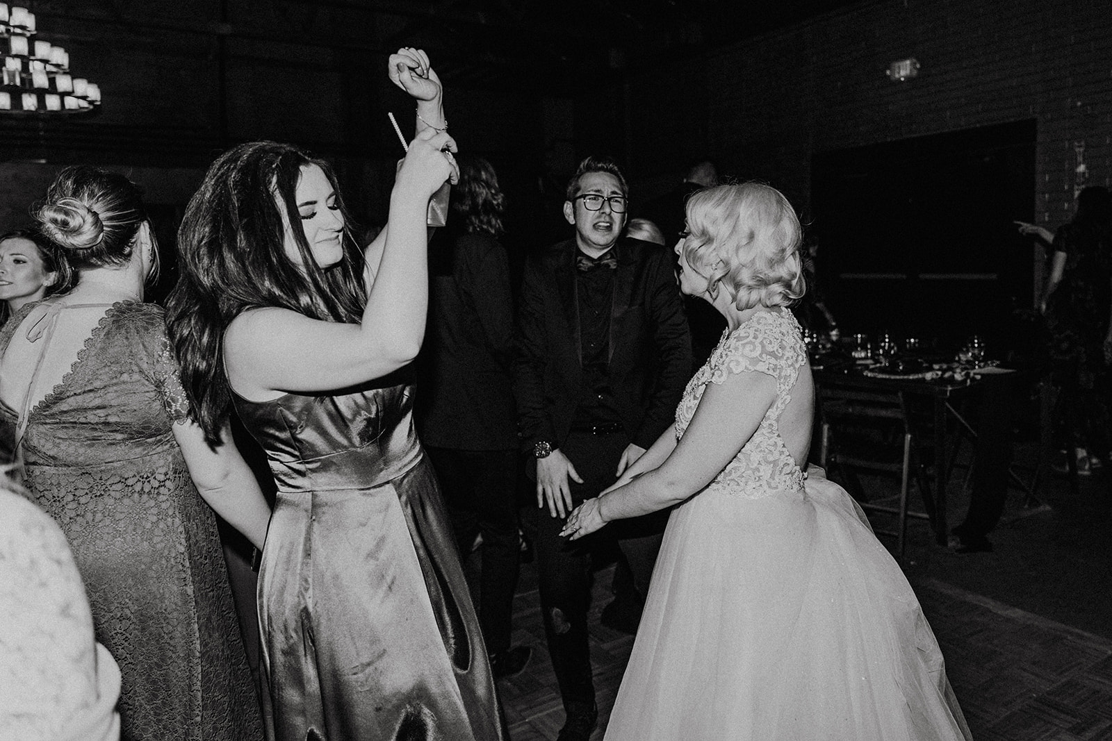 black and white candid of wedding guests dancing at reception