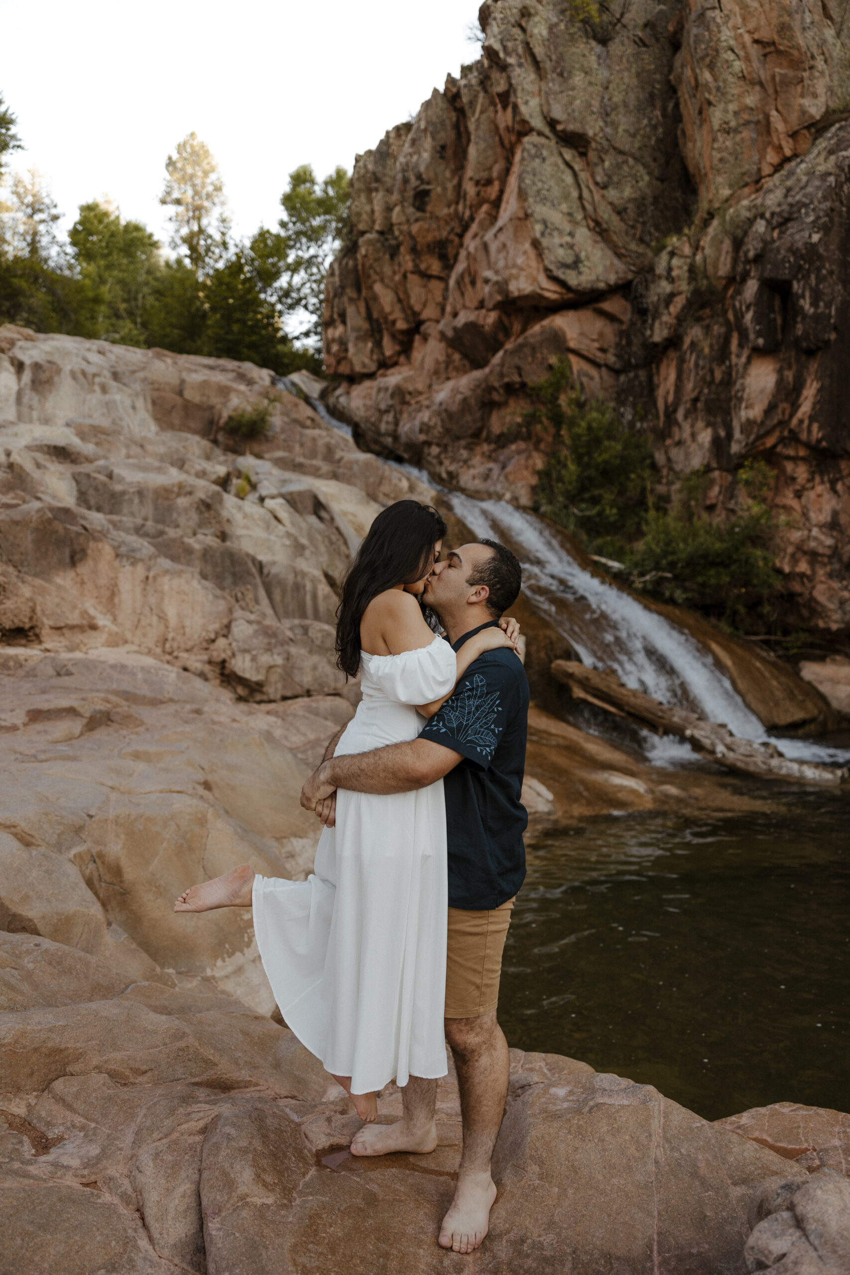 engaged couple kissing by waterfall at engagement photos