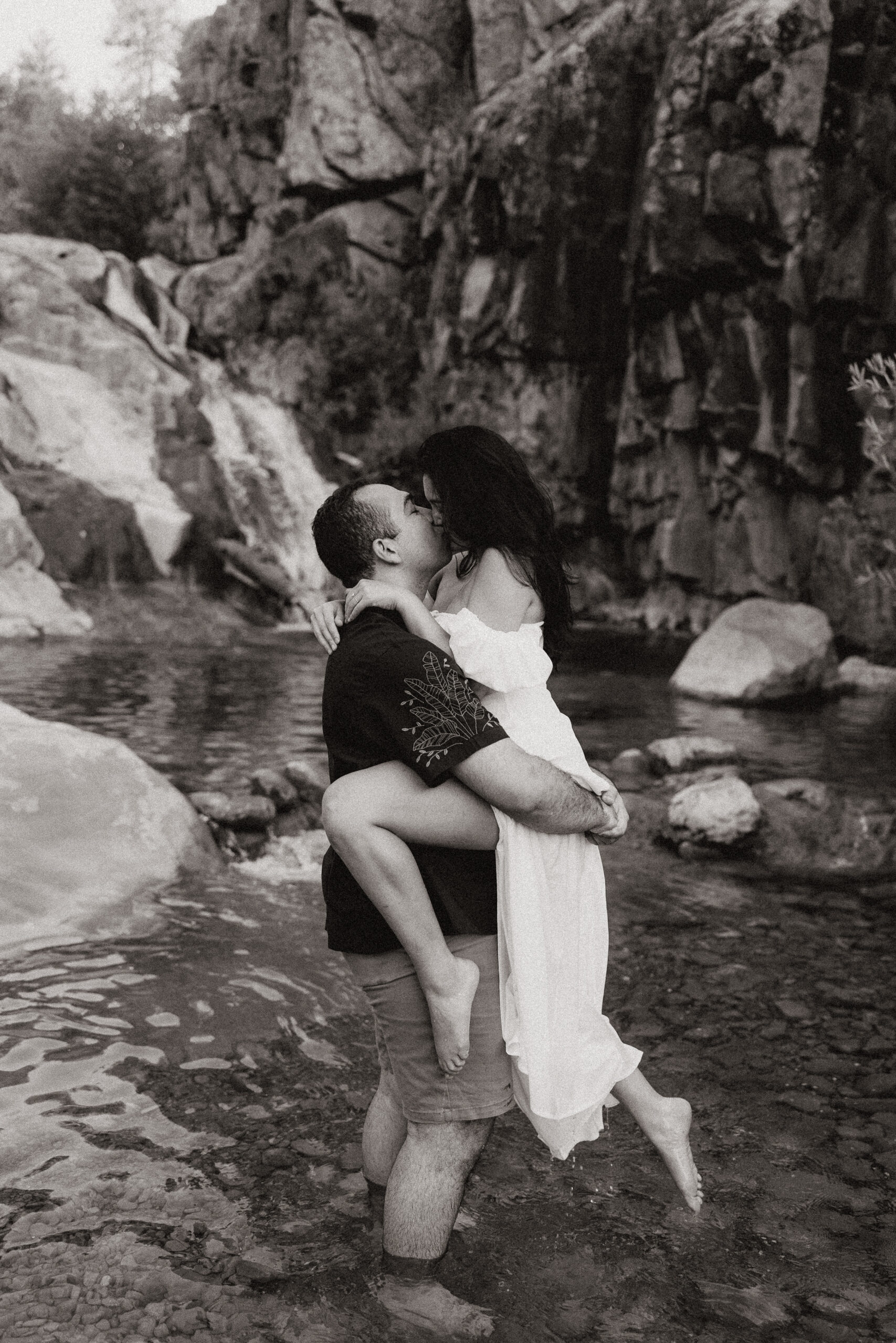 engaged couple kissing in the water 