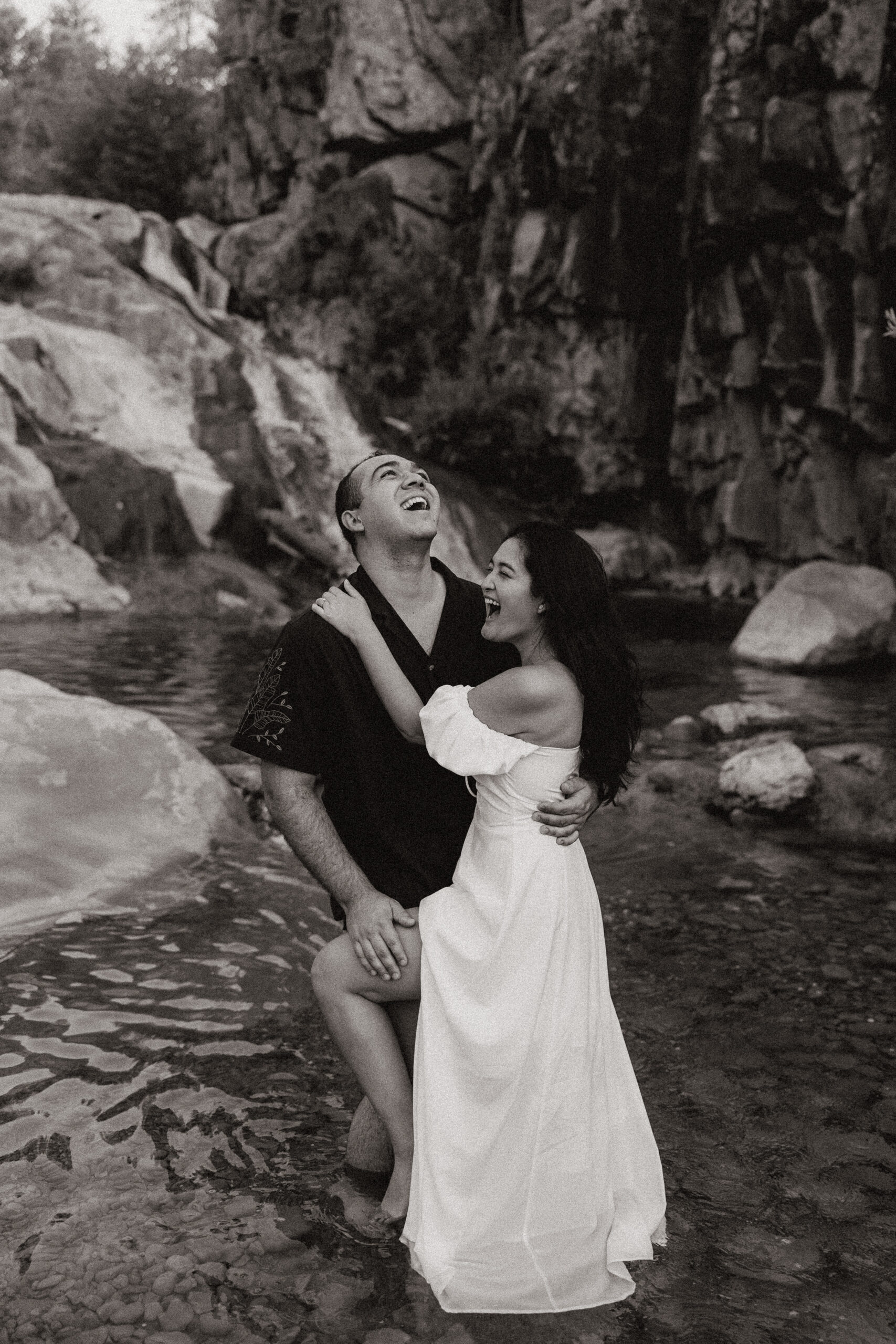 engaged couple laughing in the water 