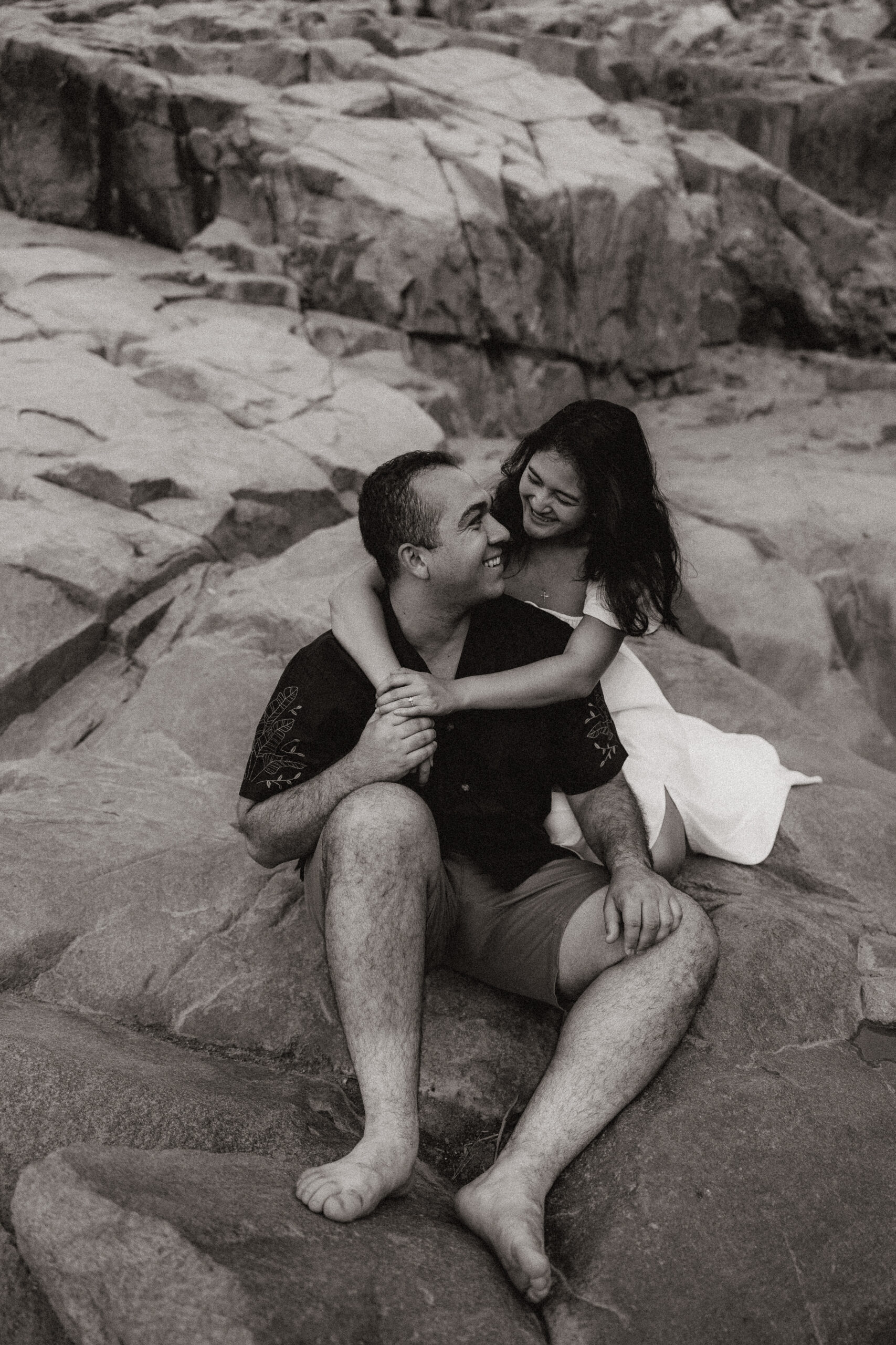 black and white of engaged couple holding each other at waterfall engagement photos