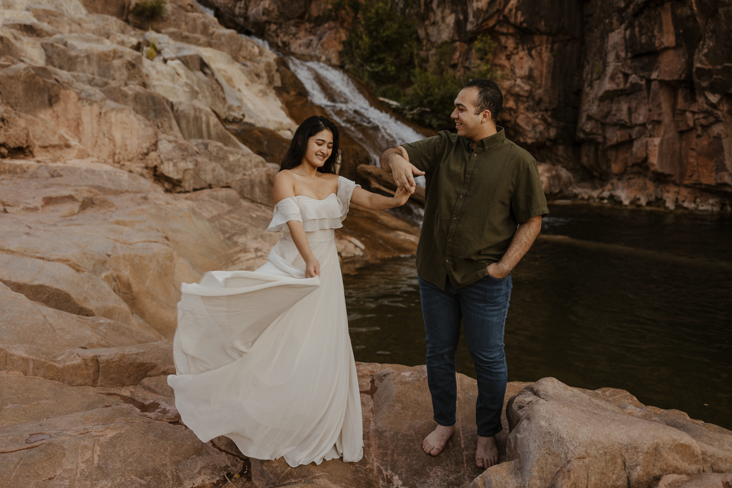engaged couple dancing in front of waterfall at engagement photos