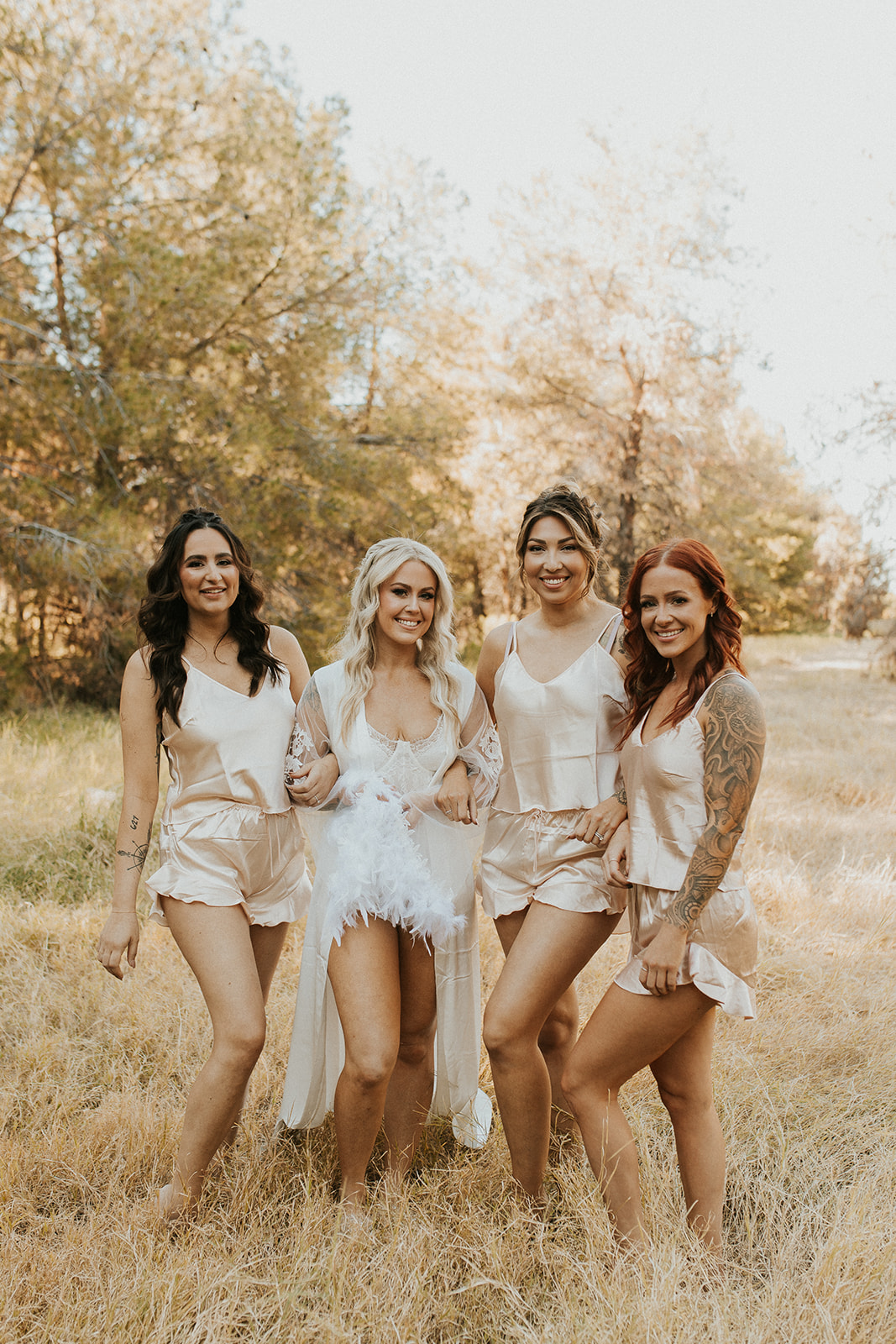 bride and bridesmaids posing outside in getting ready outfits