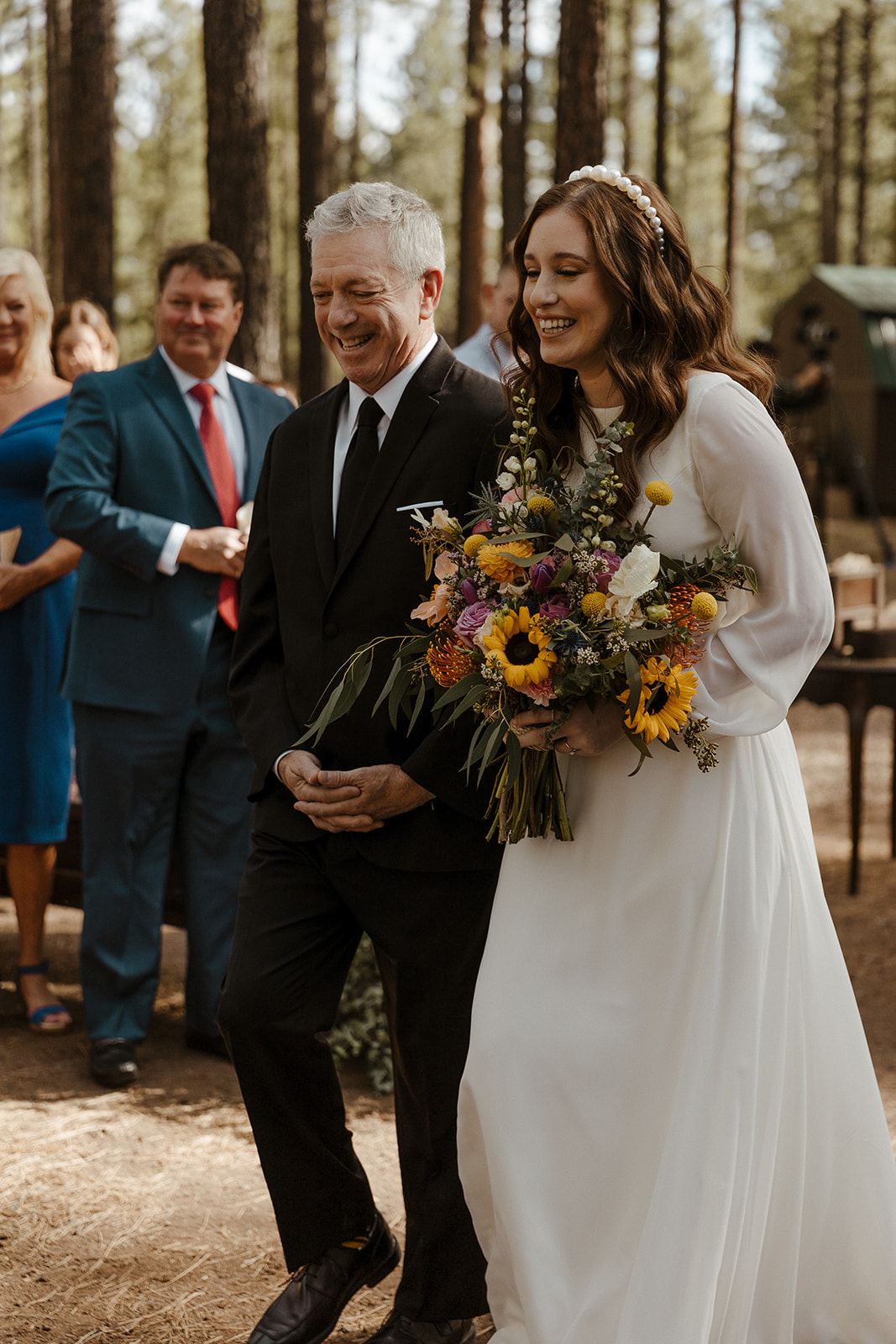 bride and her father coming down aisle smiling 