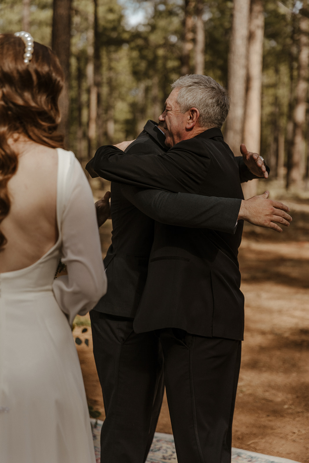 groom and father of bride hugging