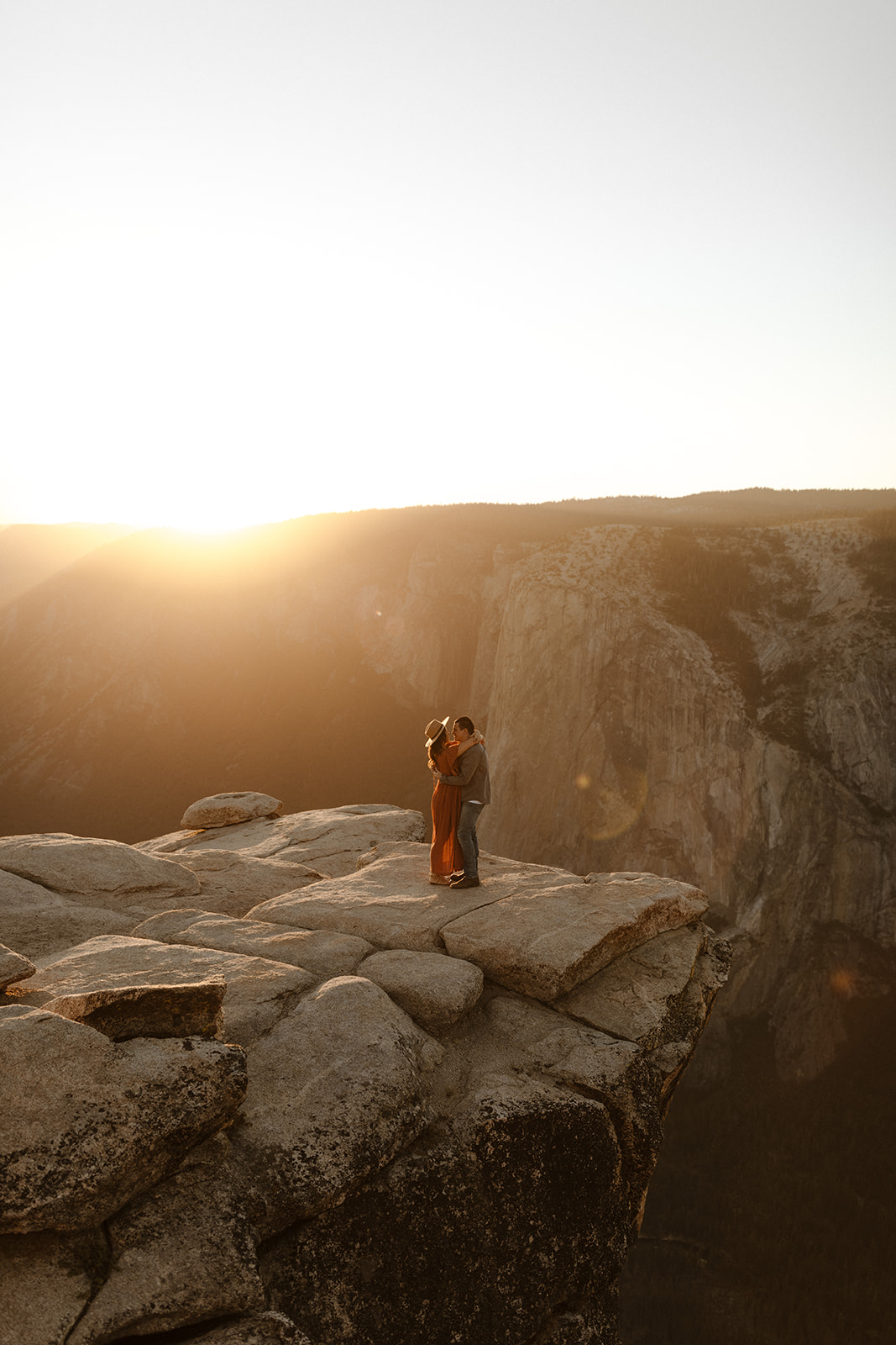 couple hugging on top of taft point in yosemite national park 