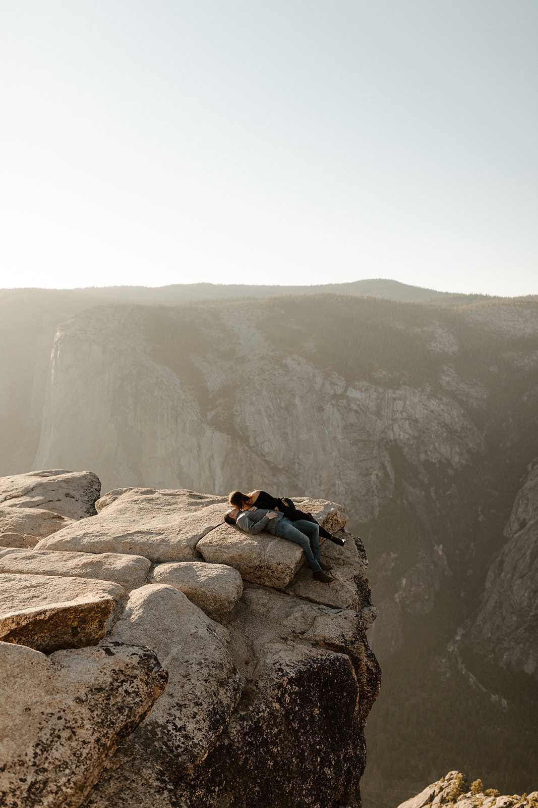 couple laying on edge of Taft Point in Yosemite Park