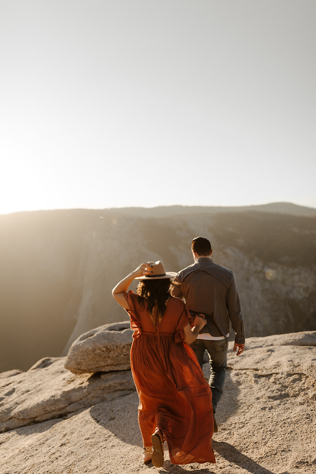 couple walking away from the camera and towards Taft Point in Yosemite Park