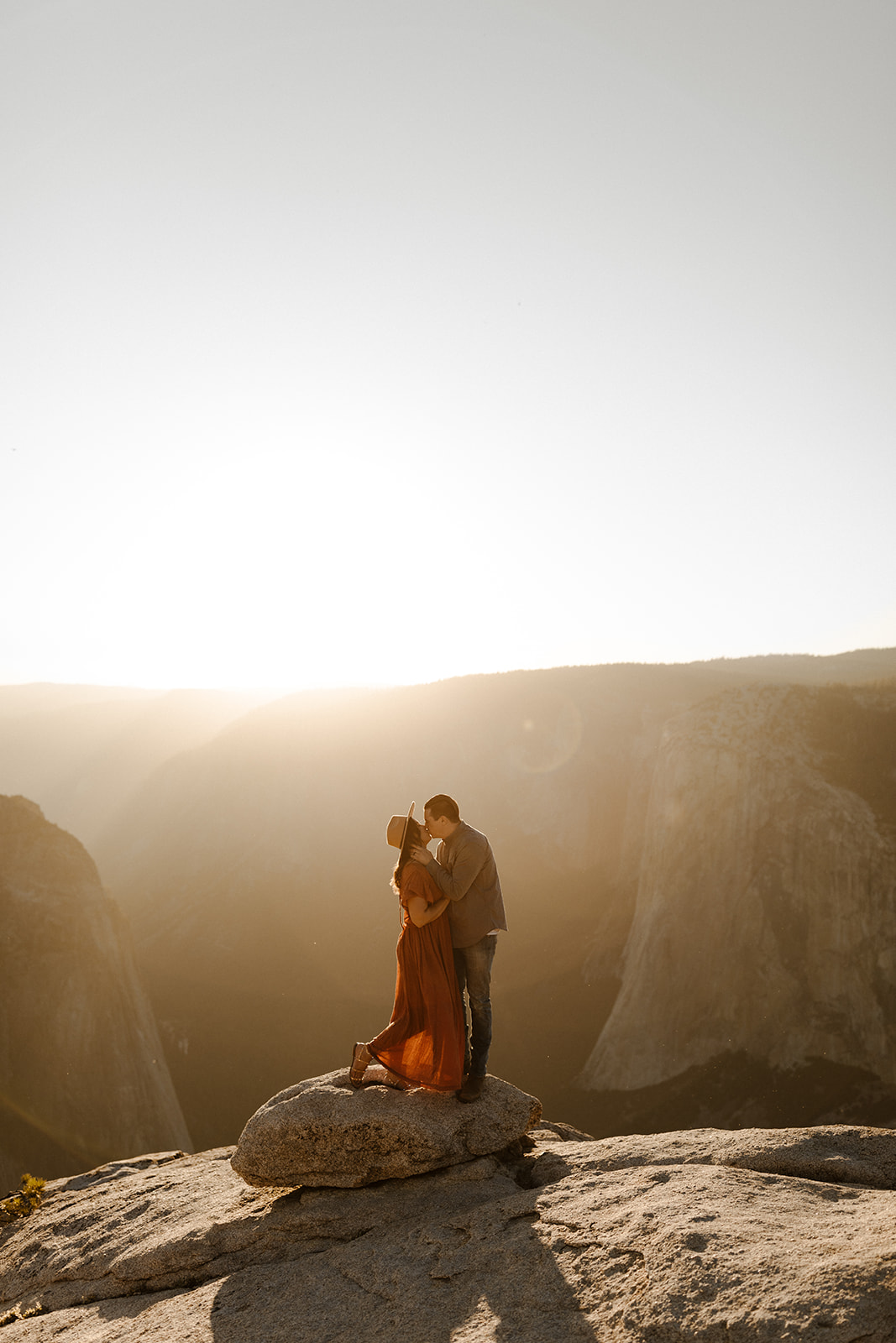 couple kissing on top of taft point in yosemite national park 