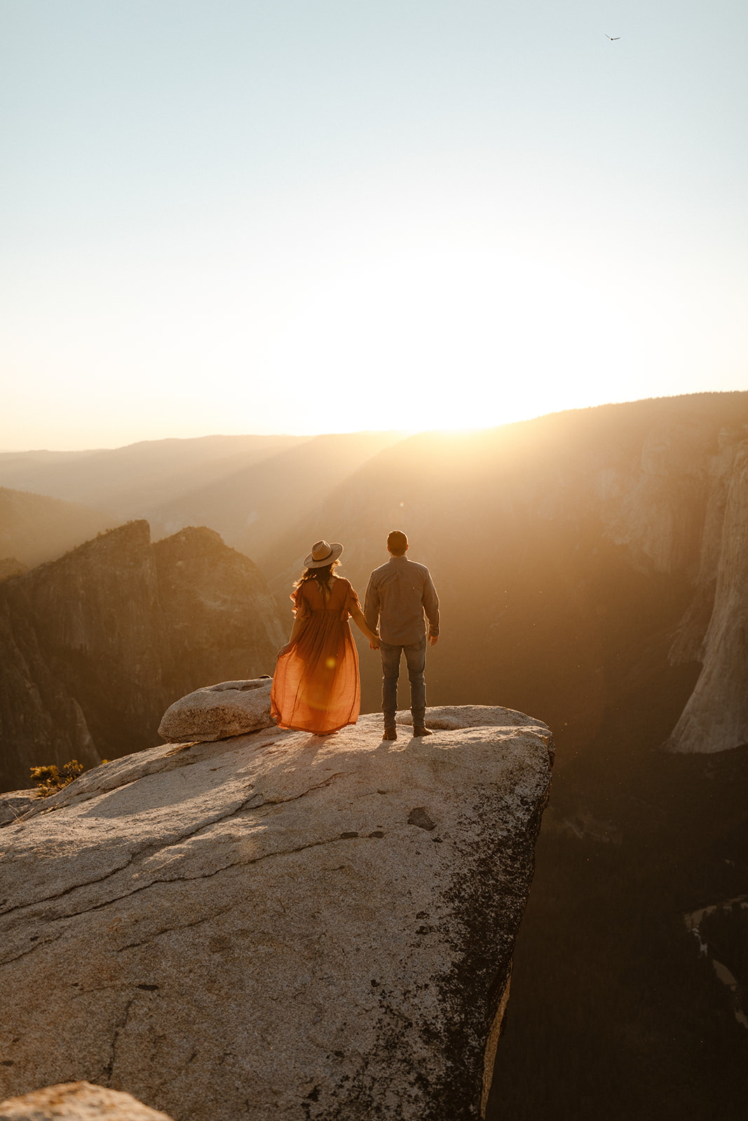 couple on top of taft point looking out into the valley in yosemite national park 