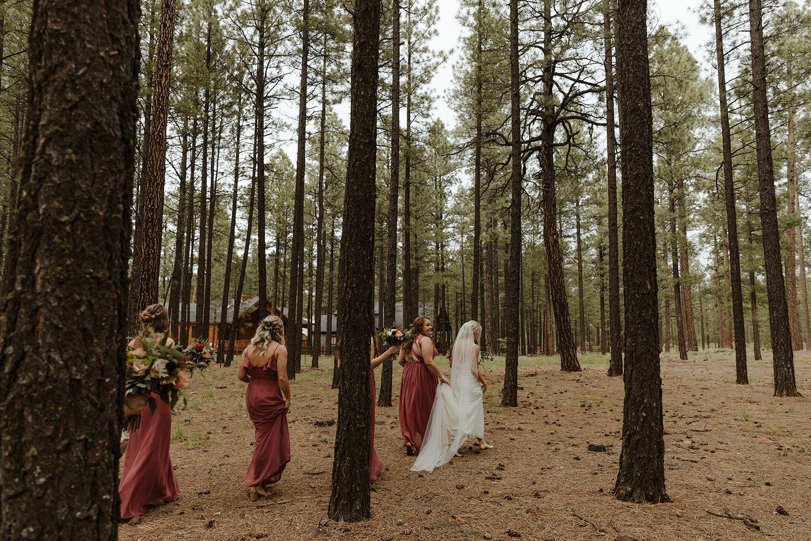 bride and bridesmaids walking in the woods