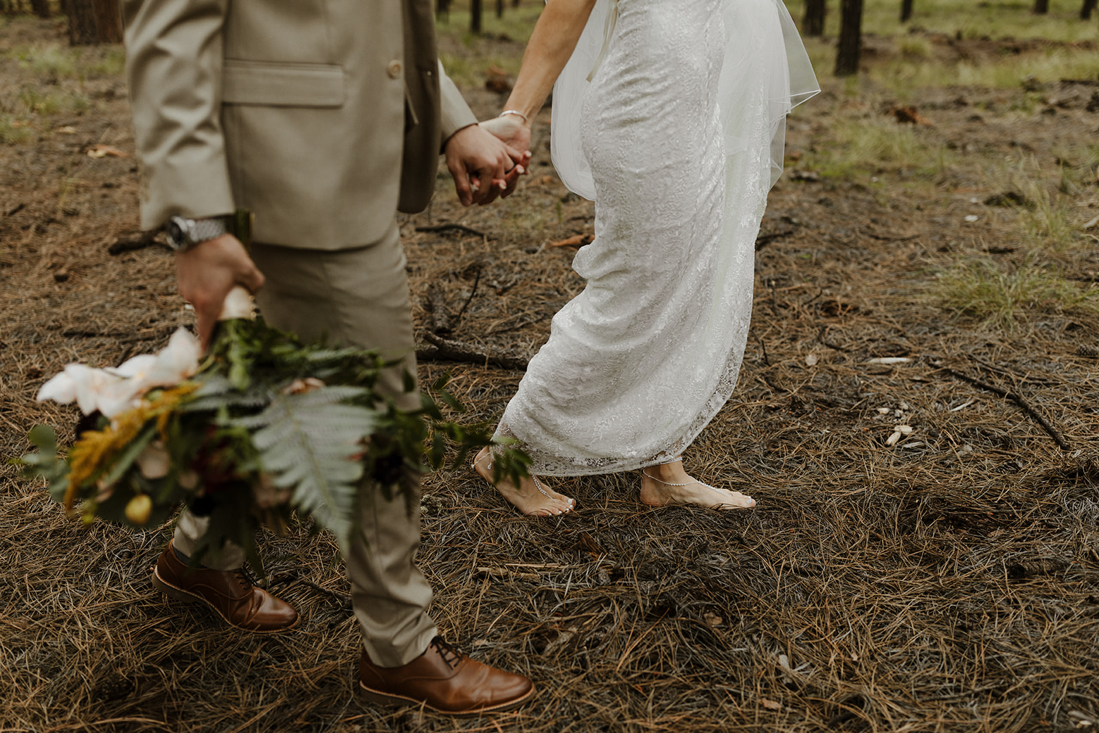 bridal couple walking barefoot in the woods at one of Arizona's forest wedding venues