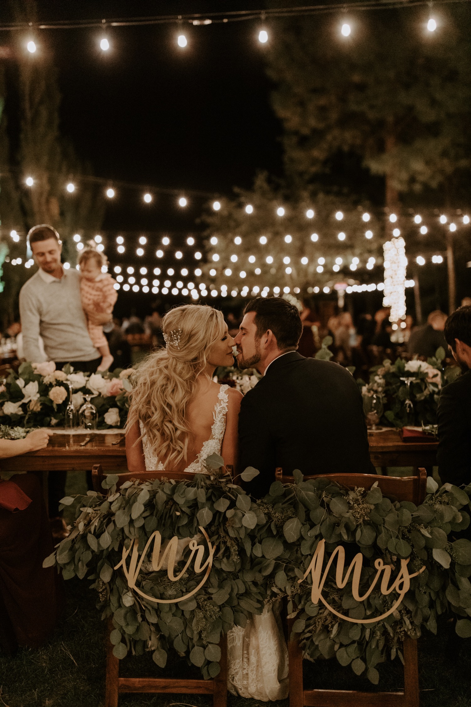 bride and groom kissing at head table 