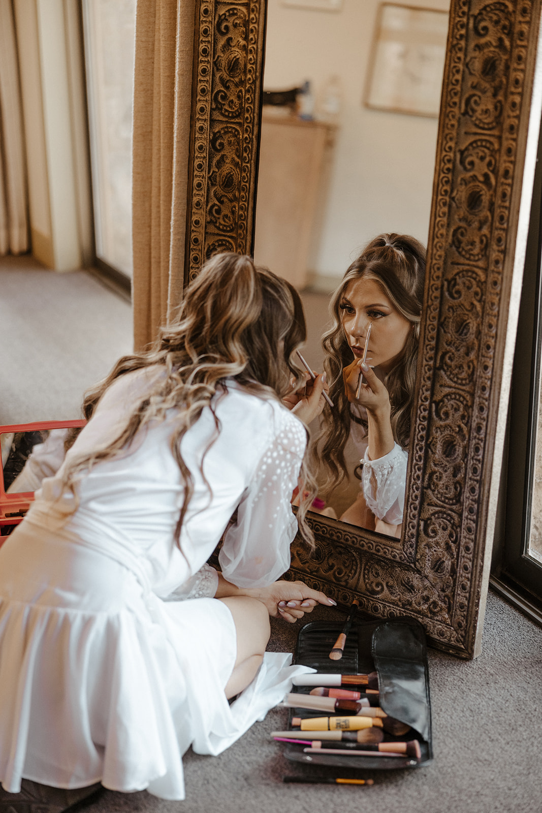 bride putting on makeup for intimate forest wedding 