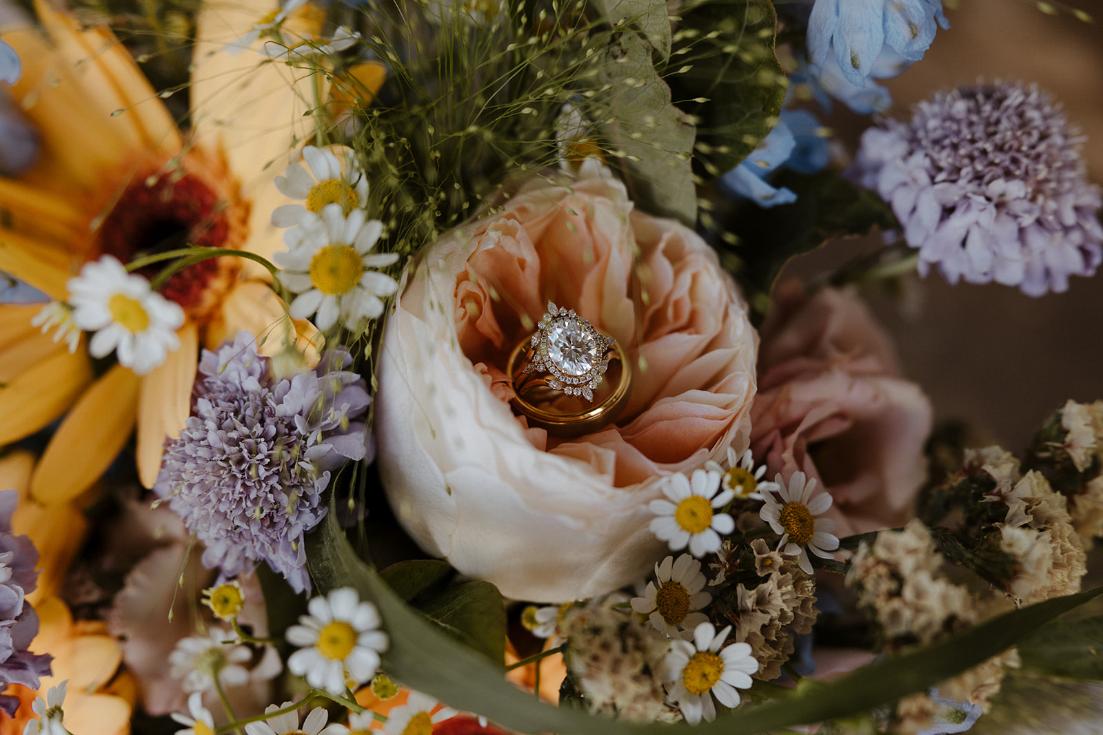 wedding rings sitting inside colorful flowers