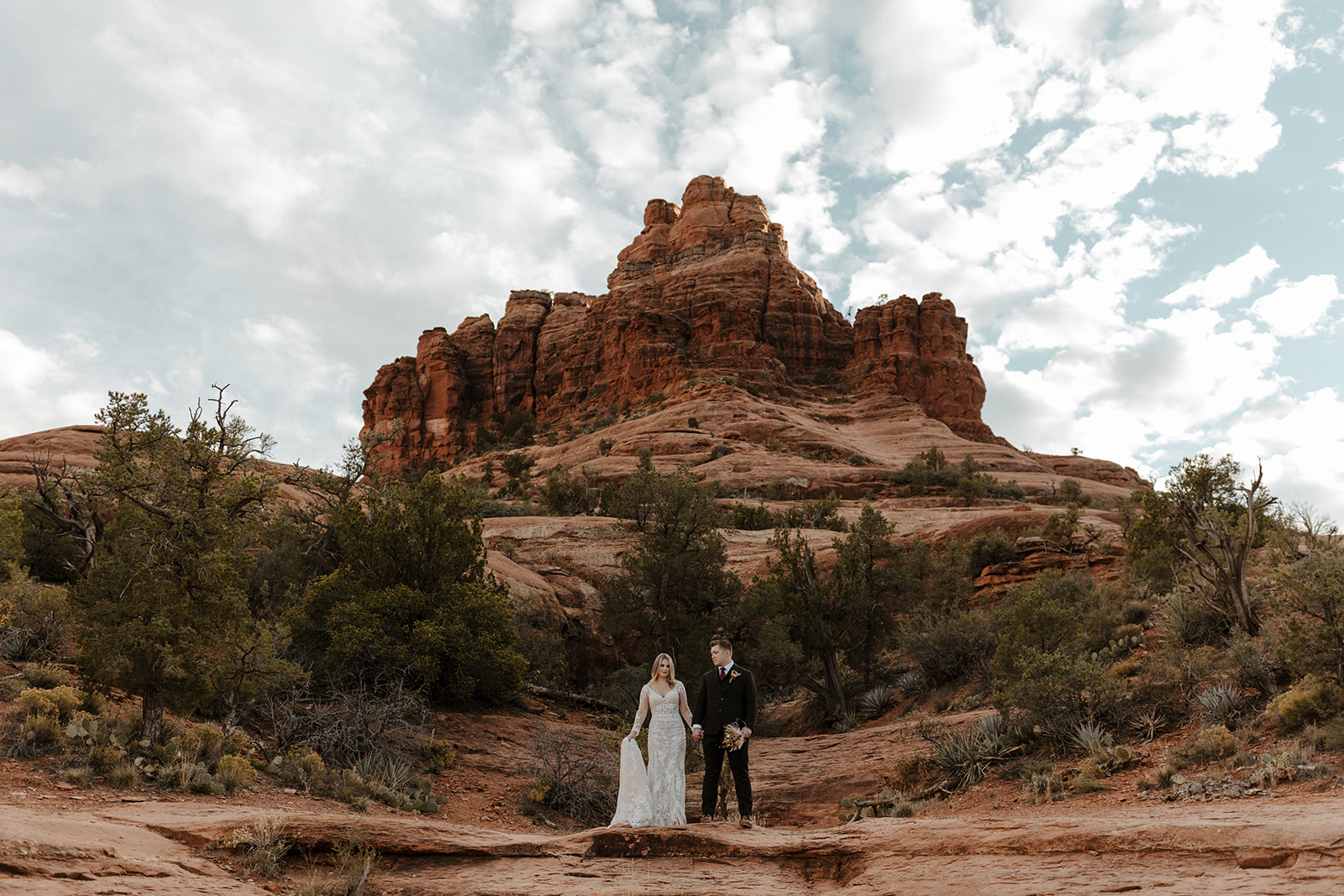 bridal couple portrait with bell rock behind them at sedona elopement wedding 