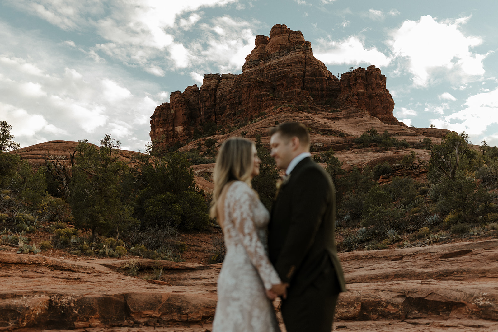 bridal couple blurred out with bell rock in focus 