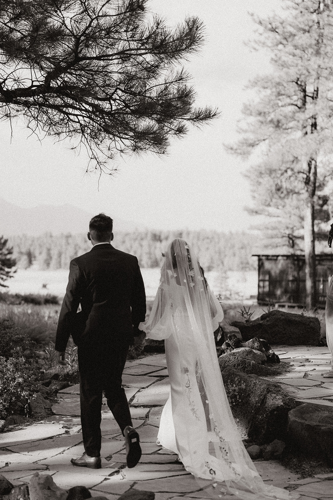 black and white of bride and groom walking away 