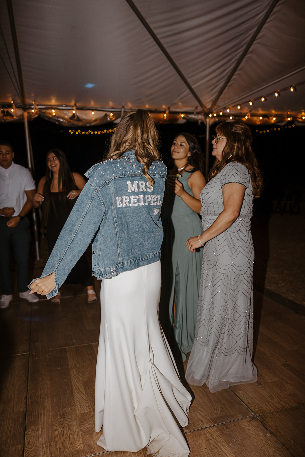 bride wearing a denim jacket with new last name on the back 