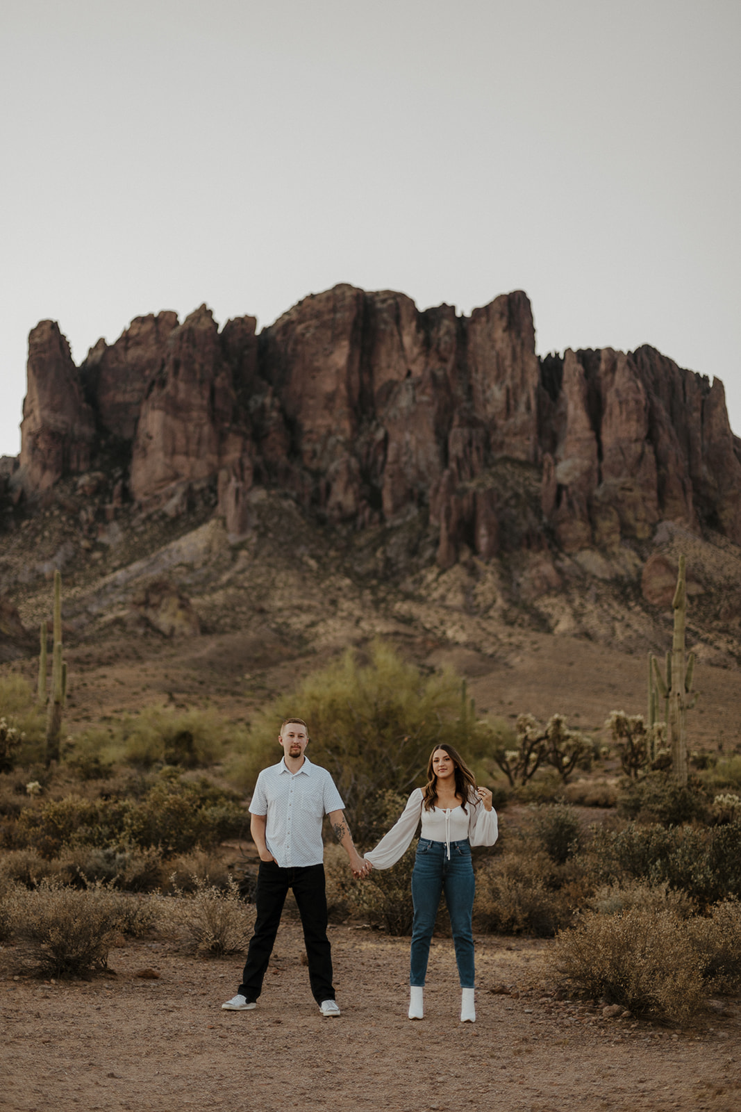 newly engaged couple holding hands with desert background at lost ducthman state park