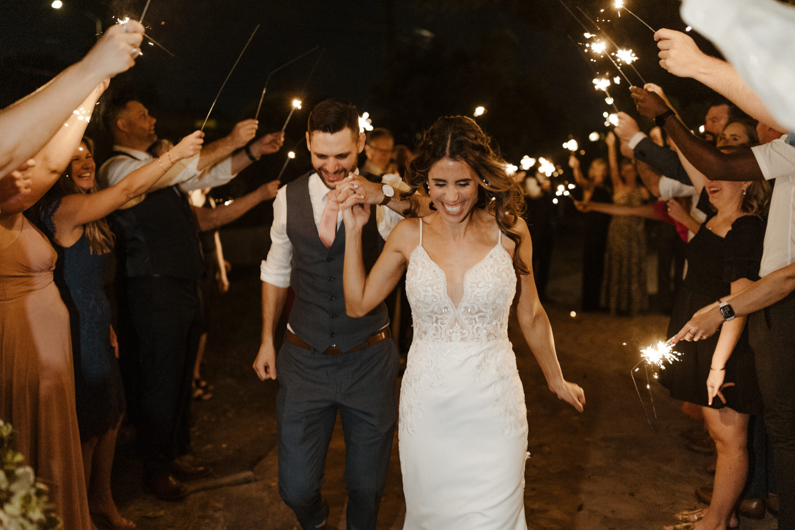 bride and groom smiling walking through sparkler exit at wright house wedding 