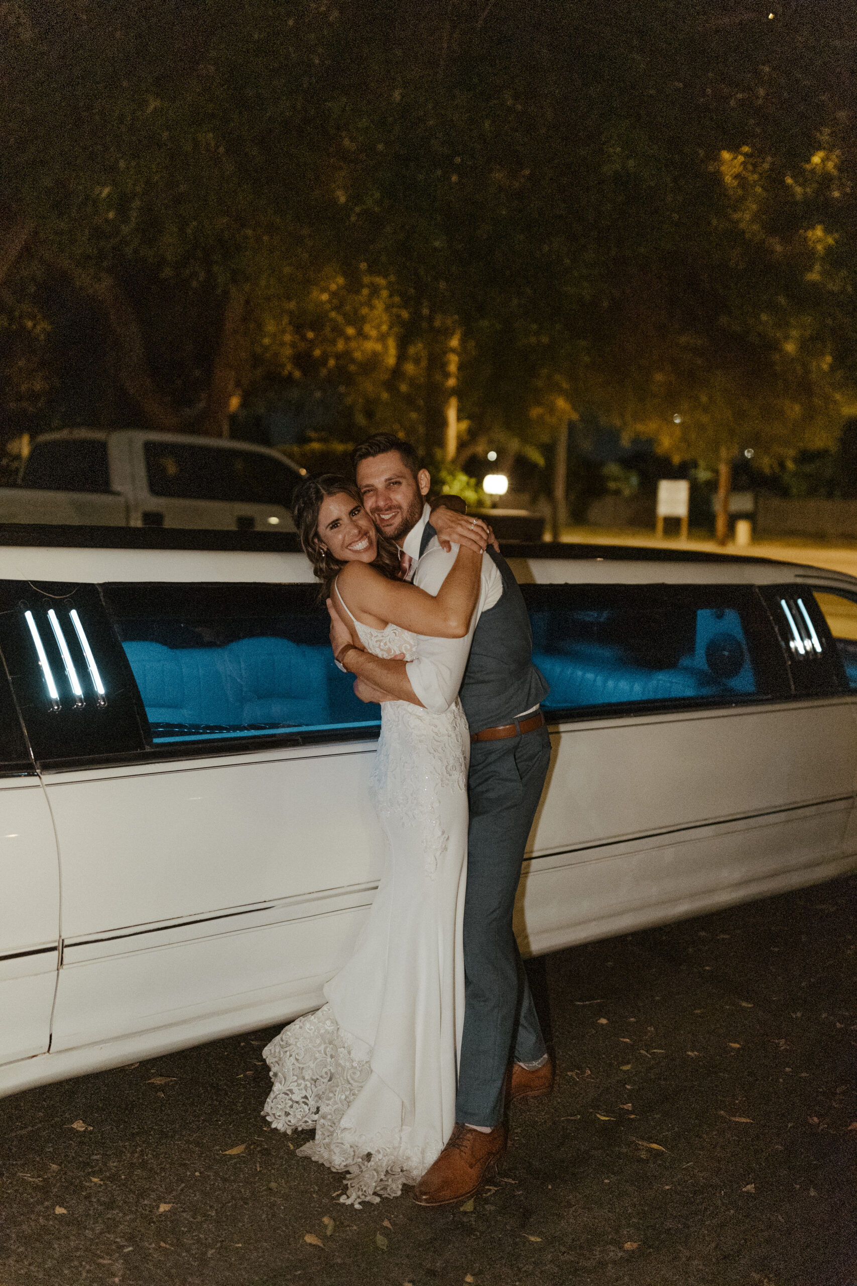 bride and groom hugging in front of limo at wright house wedding 
