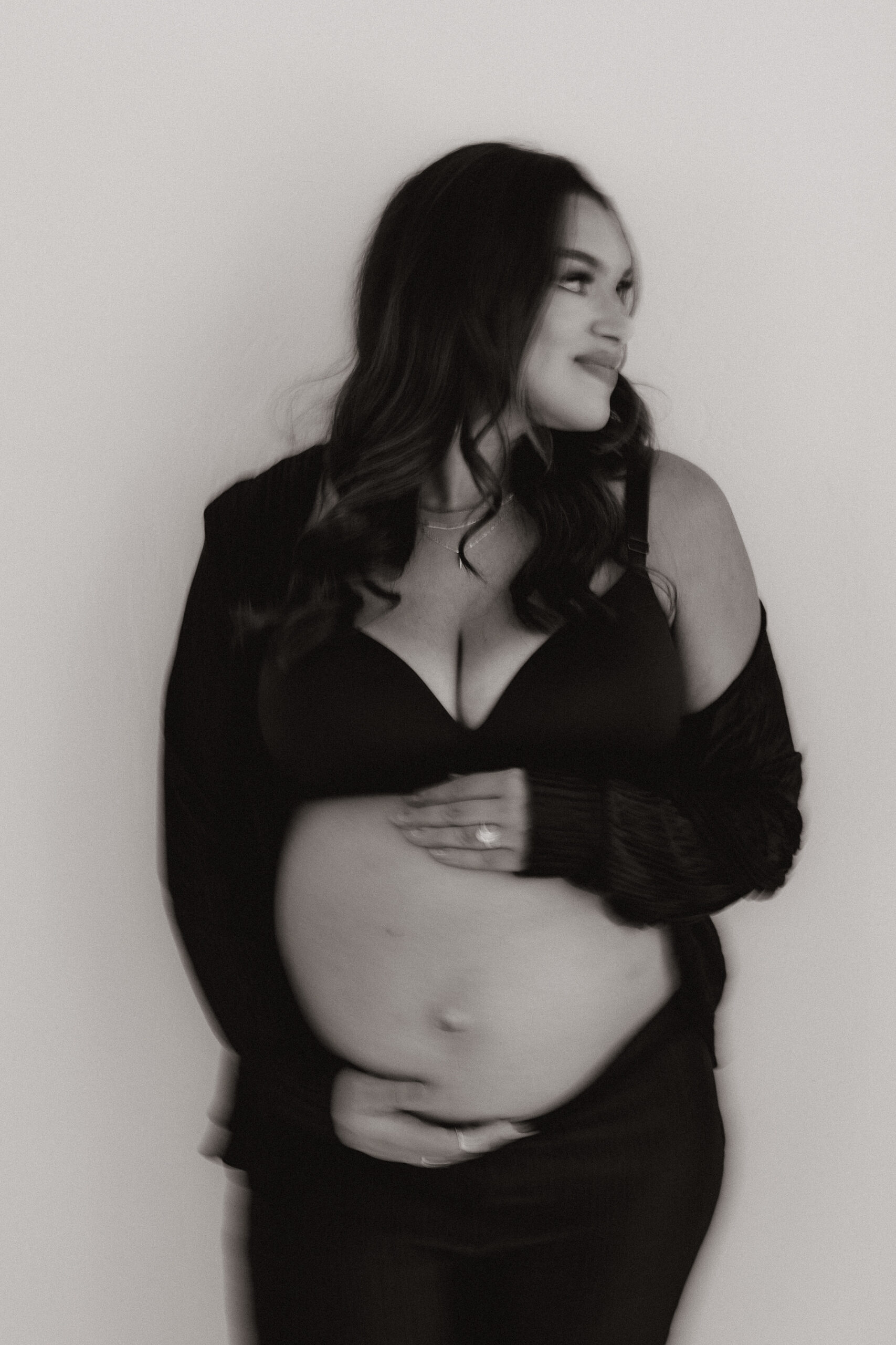 blurry photo of mom to be holding her stomach during editorial maternity photoshoot