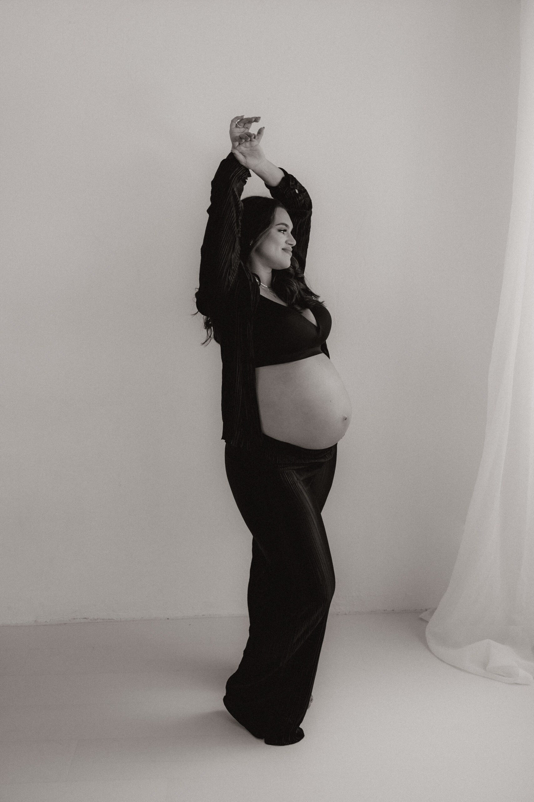 mom to be with both arms above her head during editorial maternity photoshoot