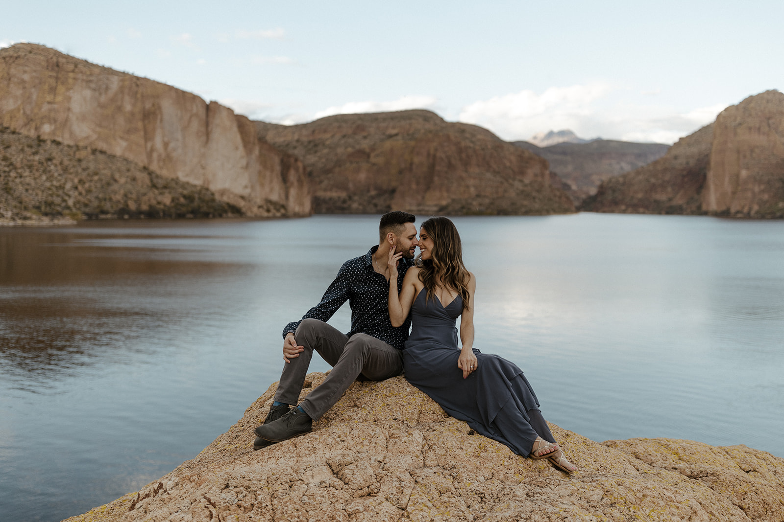 couple sitting on a rock by the lake in arizona 