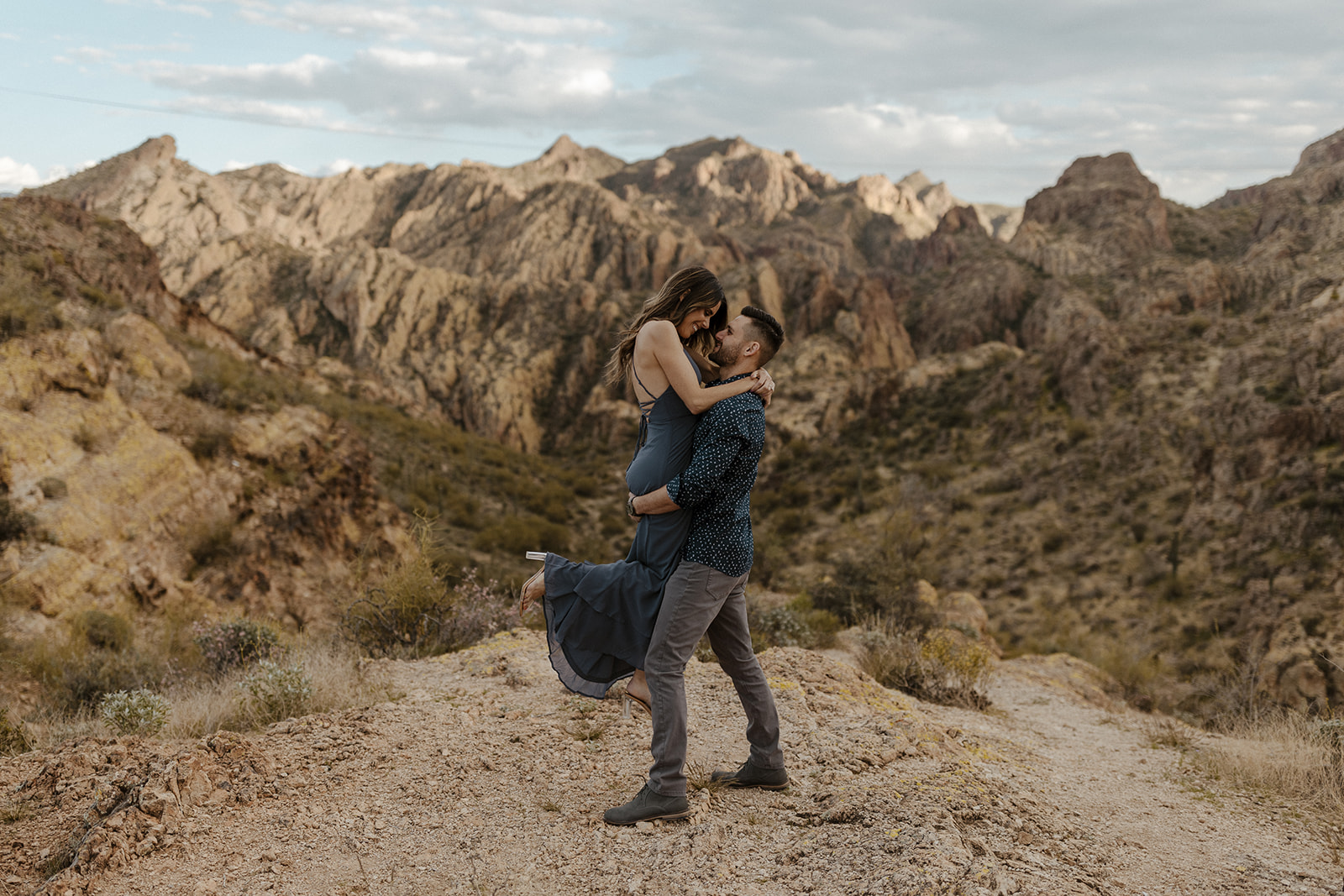 one fiance holding the other one off the ground during canyon lake arizona engagement pictures