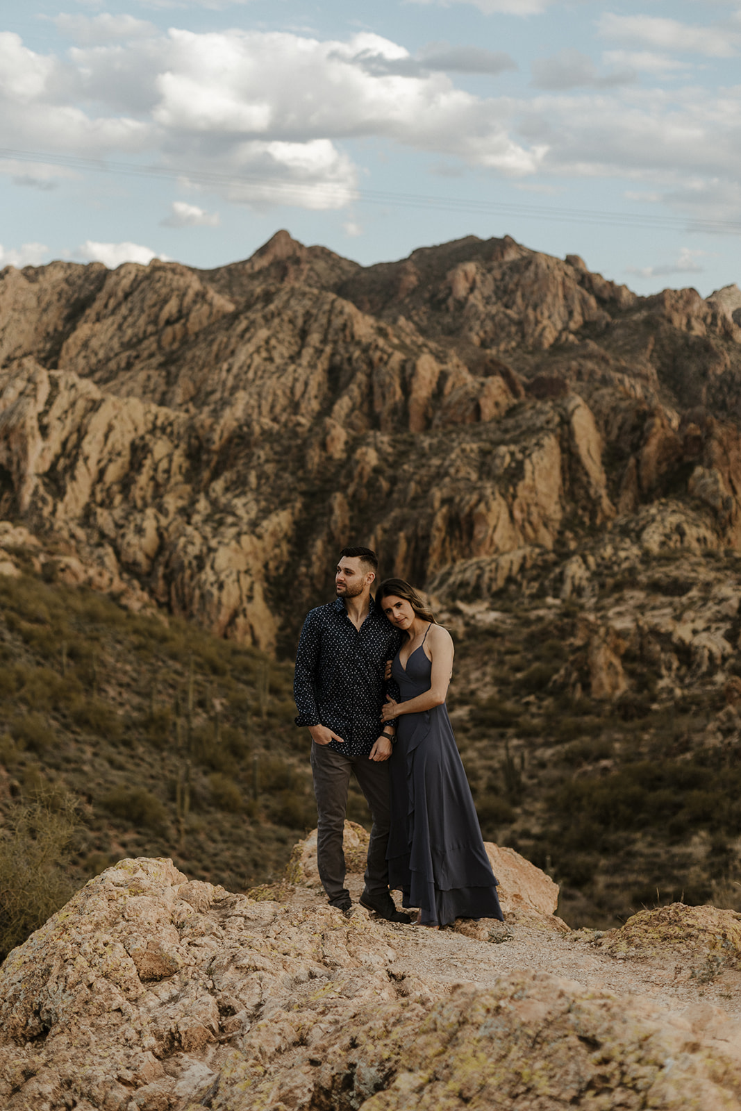 newly engaged couple holding each other arms in the mountains during engagement photos