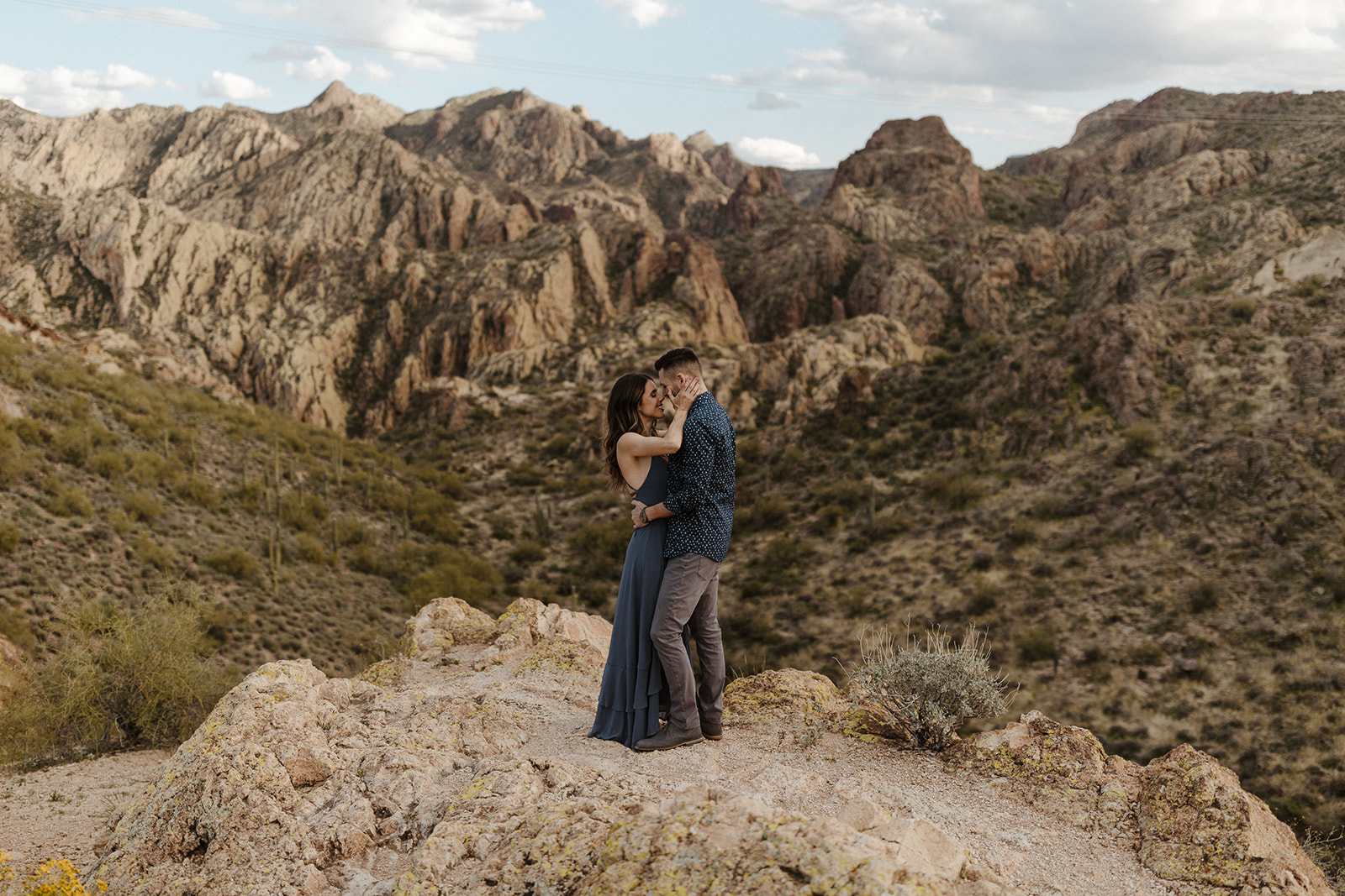 newly engaged couple holding each other with the mountains in the background during canyon lake arizona engagement pictures