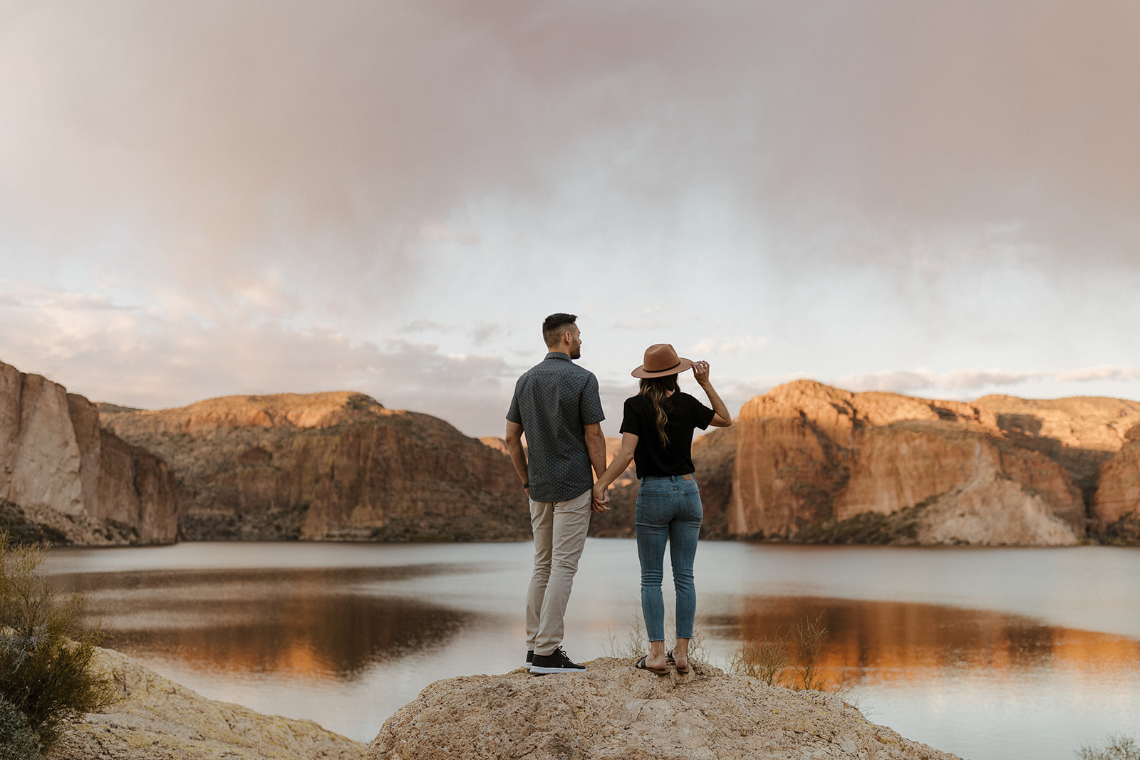couple standing on a rock during sunset at canyon lake in az