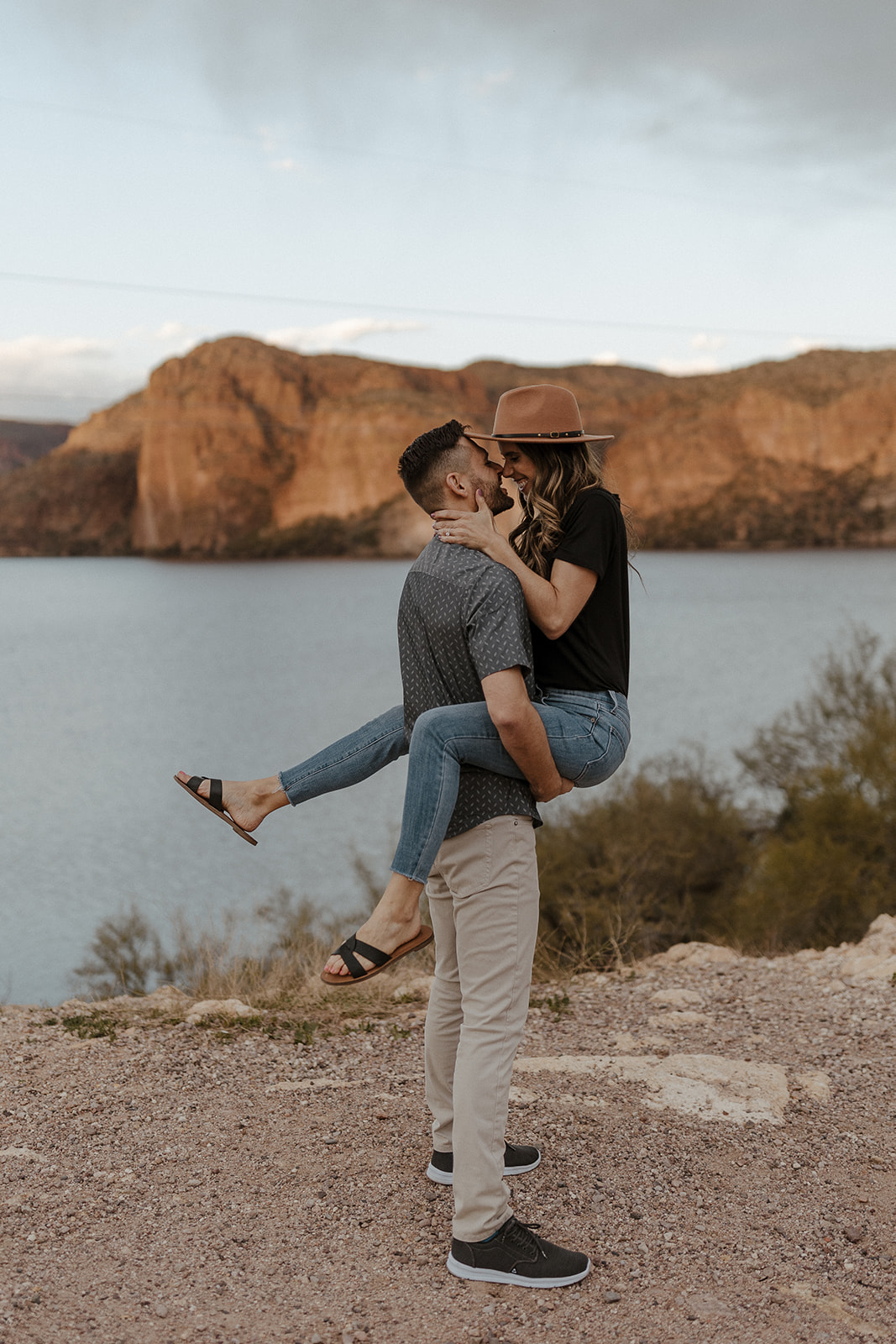 fiance holding other fiance by the lake during their engagement session 