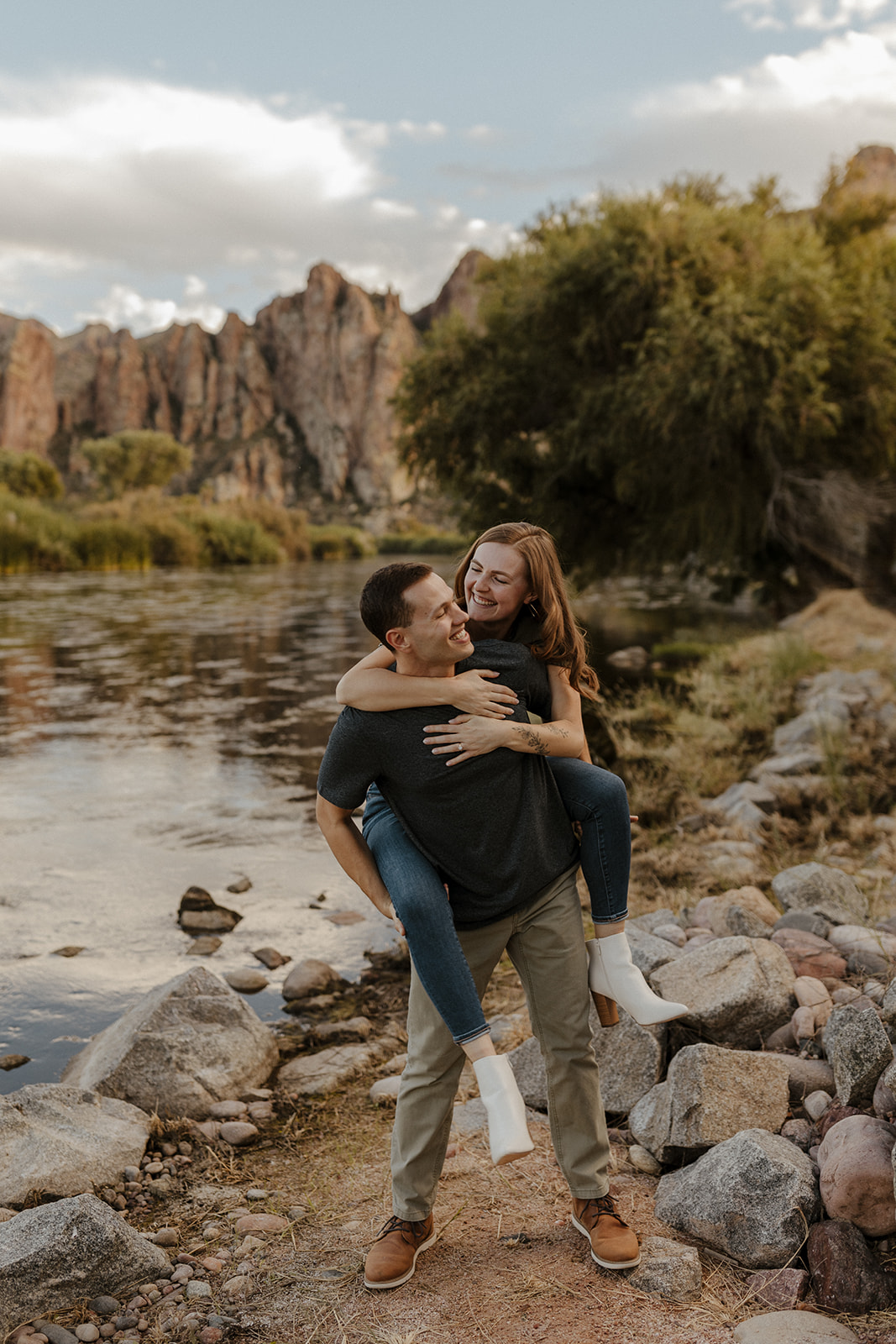 fiance on other fiances back by the river at engagement session 