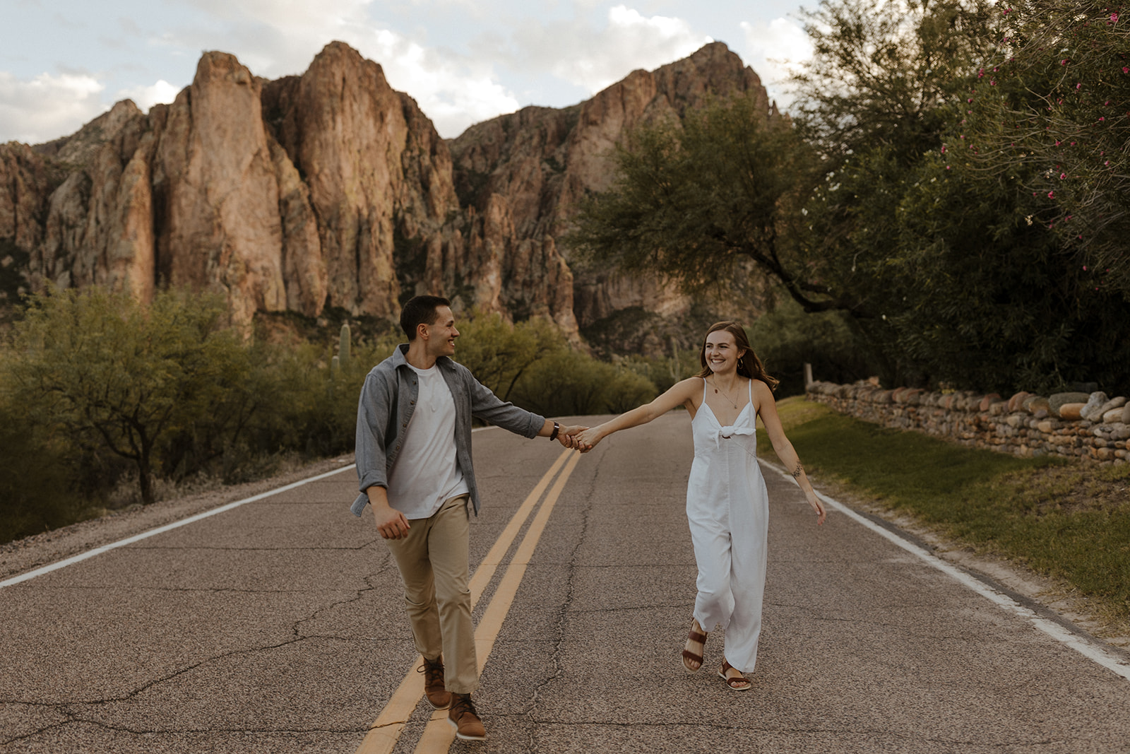 couple holding hands smiling and walking on the street at saguaro lake guest ranch Arizona 