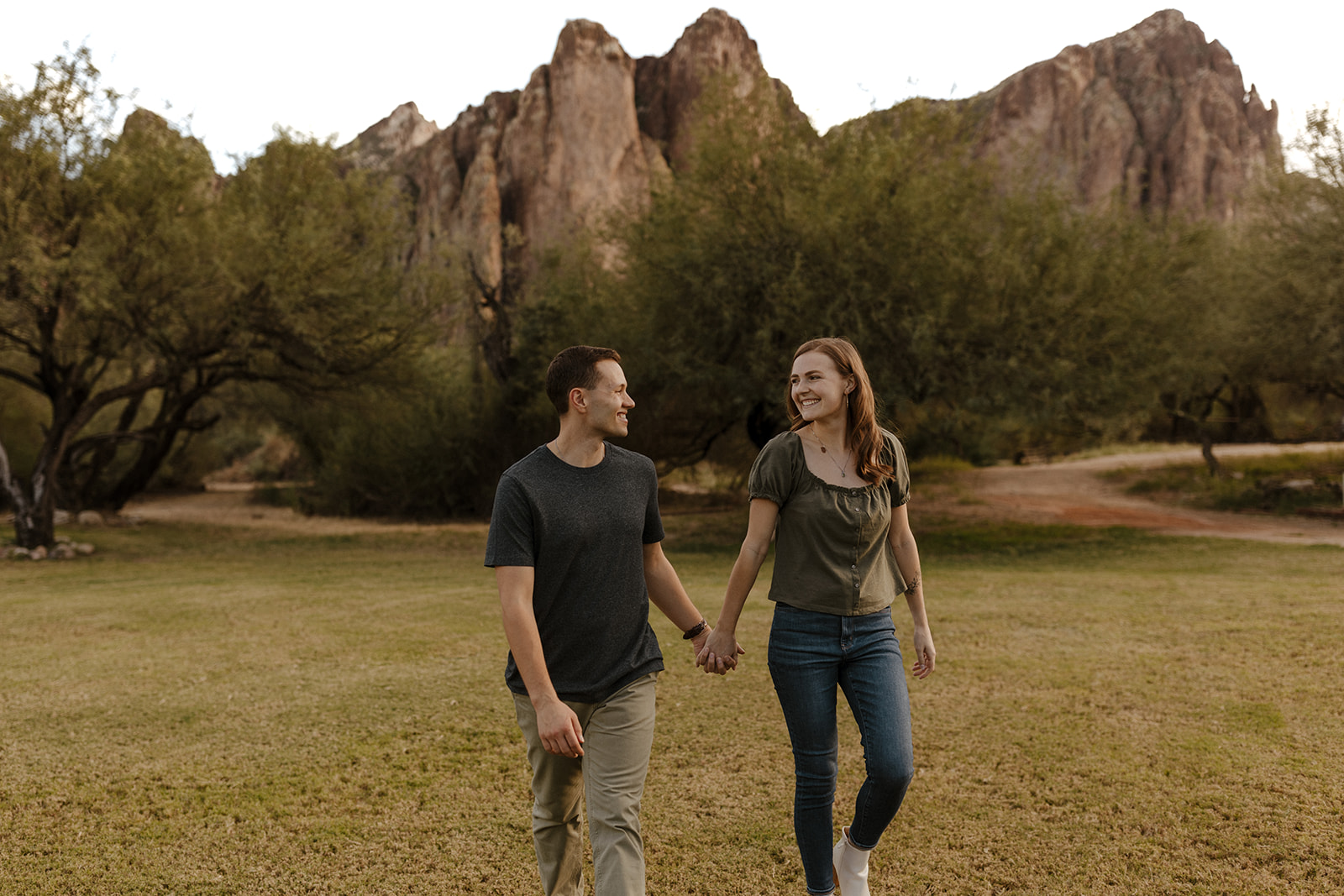 couple holding hands smiling and walking at saguaro lake guest ranch Arizona 